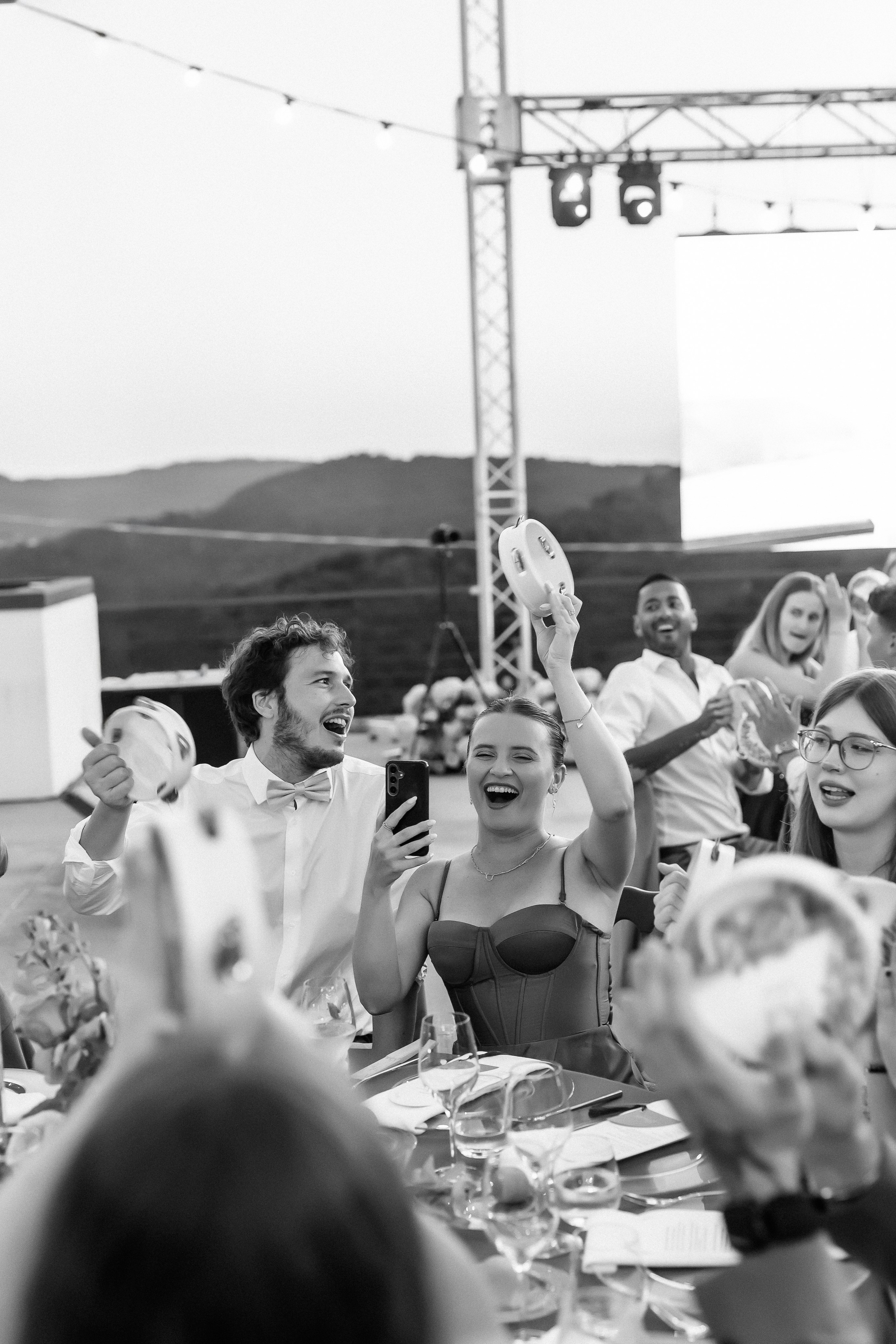 Black and white photo of guests cheering during the reception