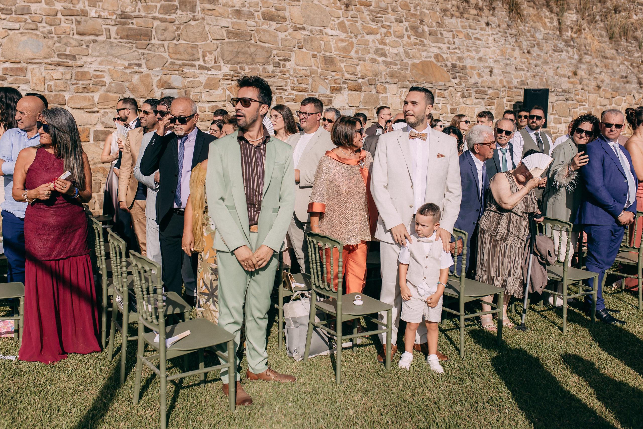 Guests standing as the bride walks down the aisle at the castle