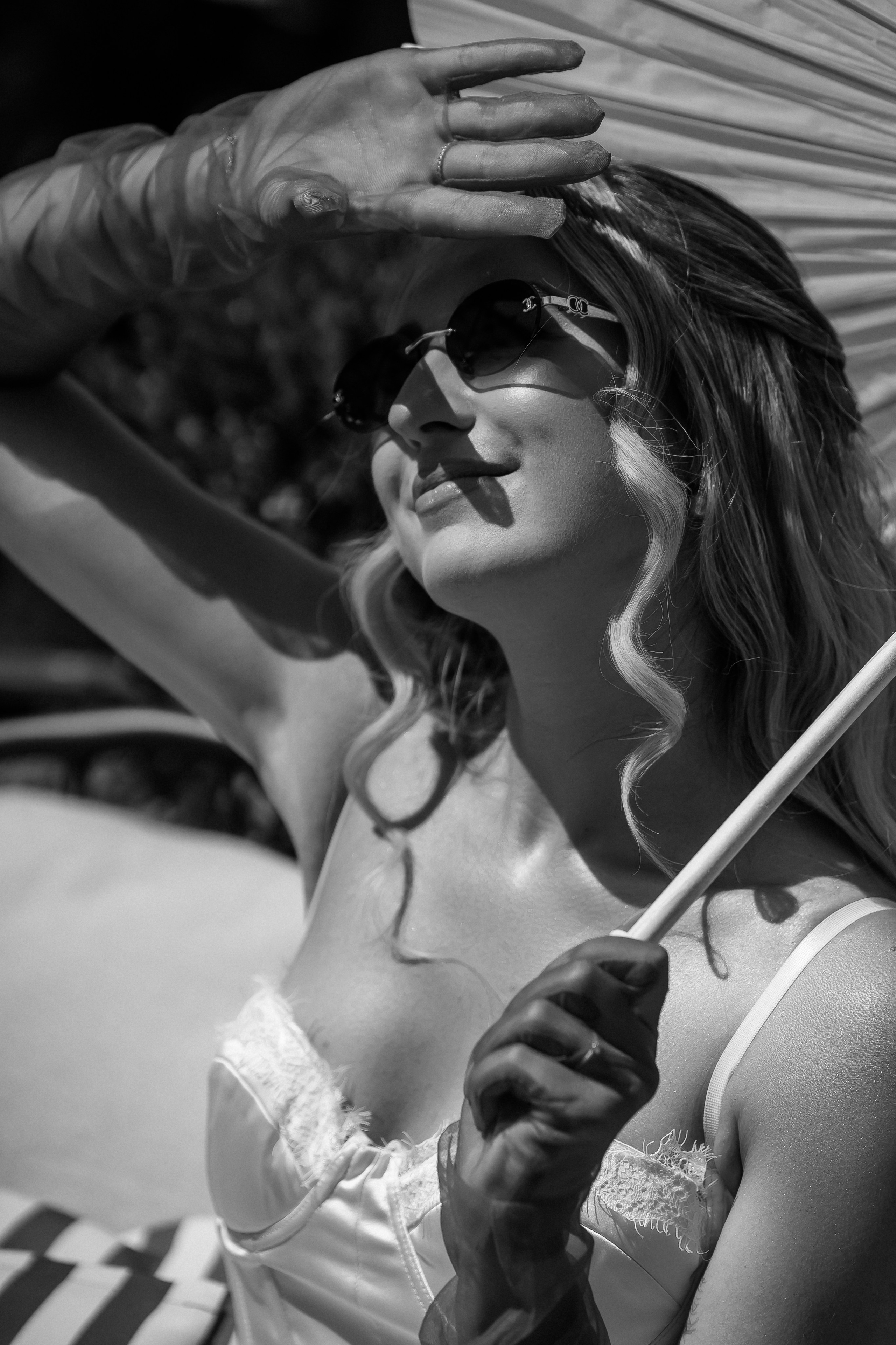 Black and white portrait of the bride in sunglasses with a parasol