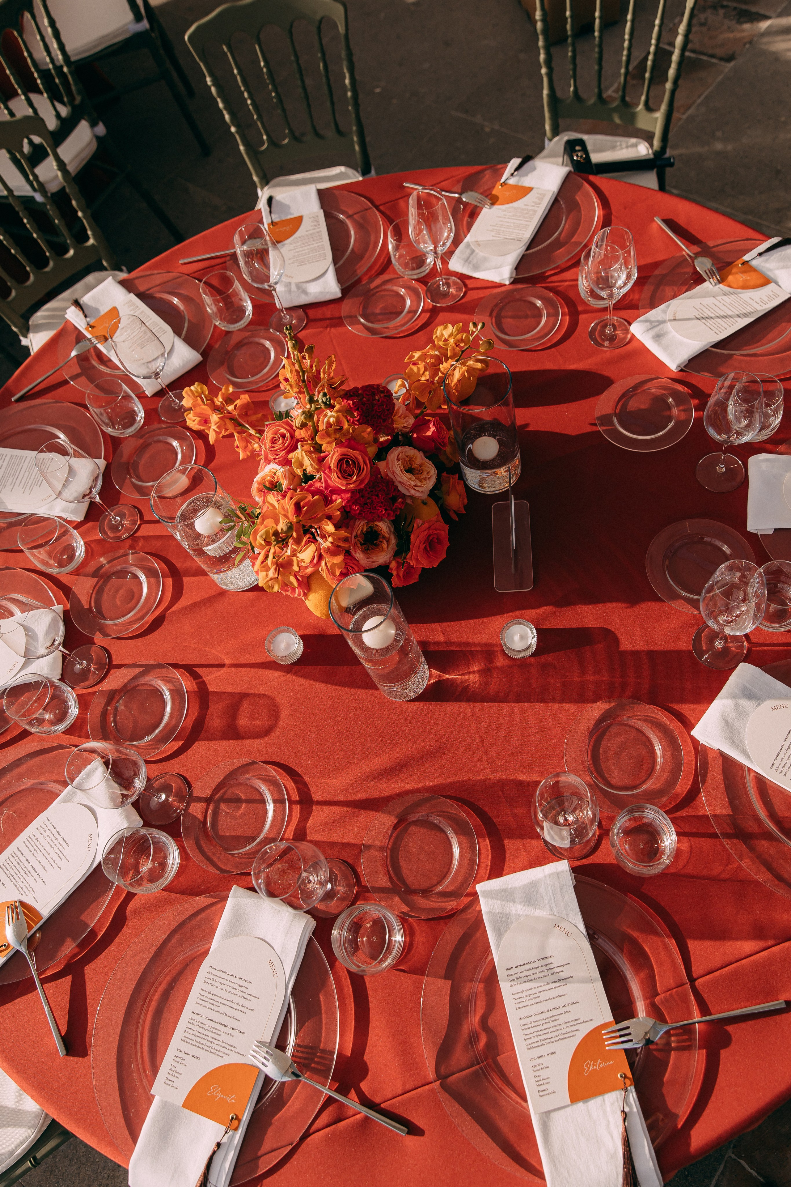 Round reception table with an orange and red floral centrepiece