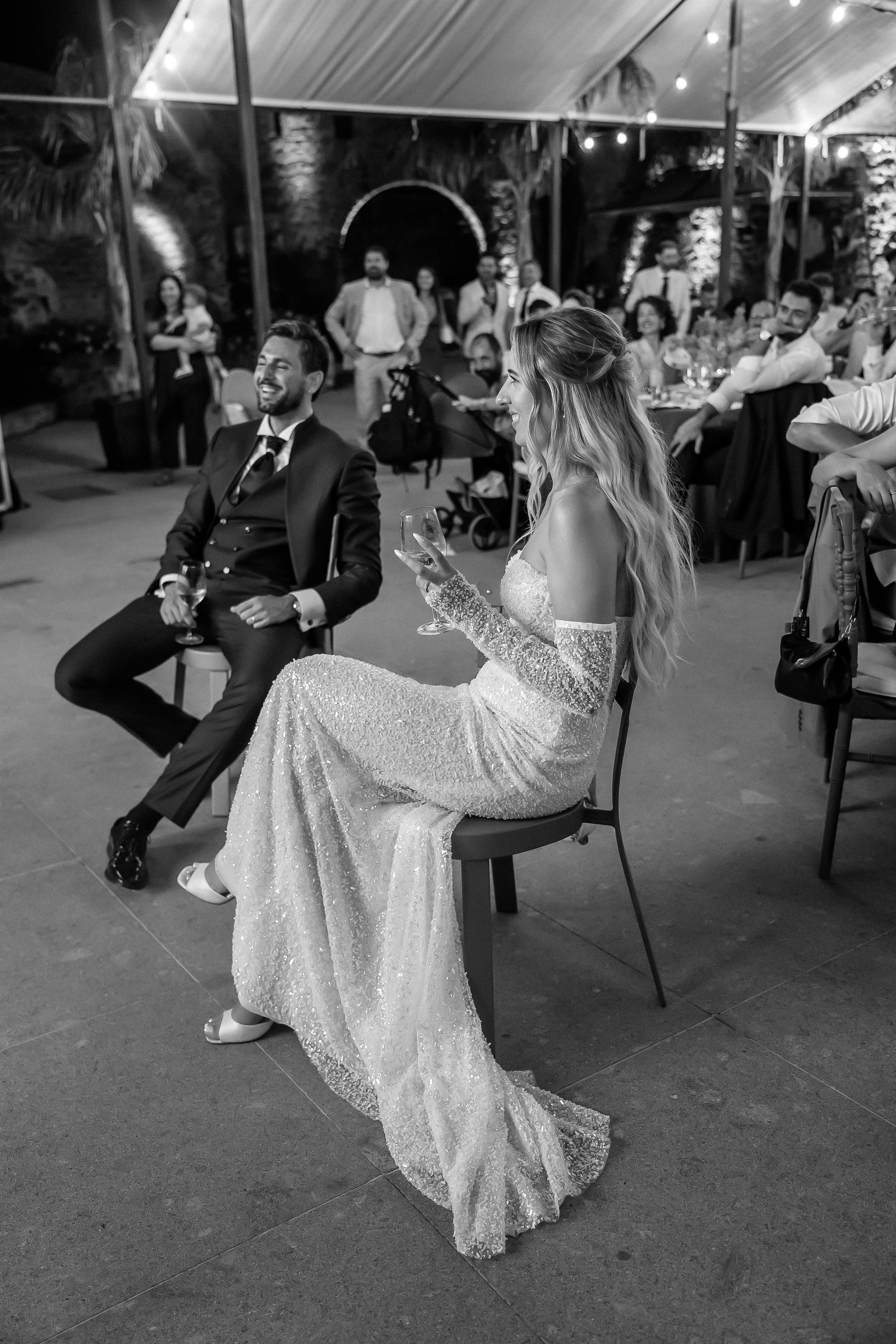 Black and white photo of the bride and groom watching the party