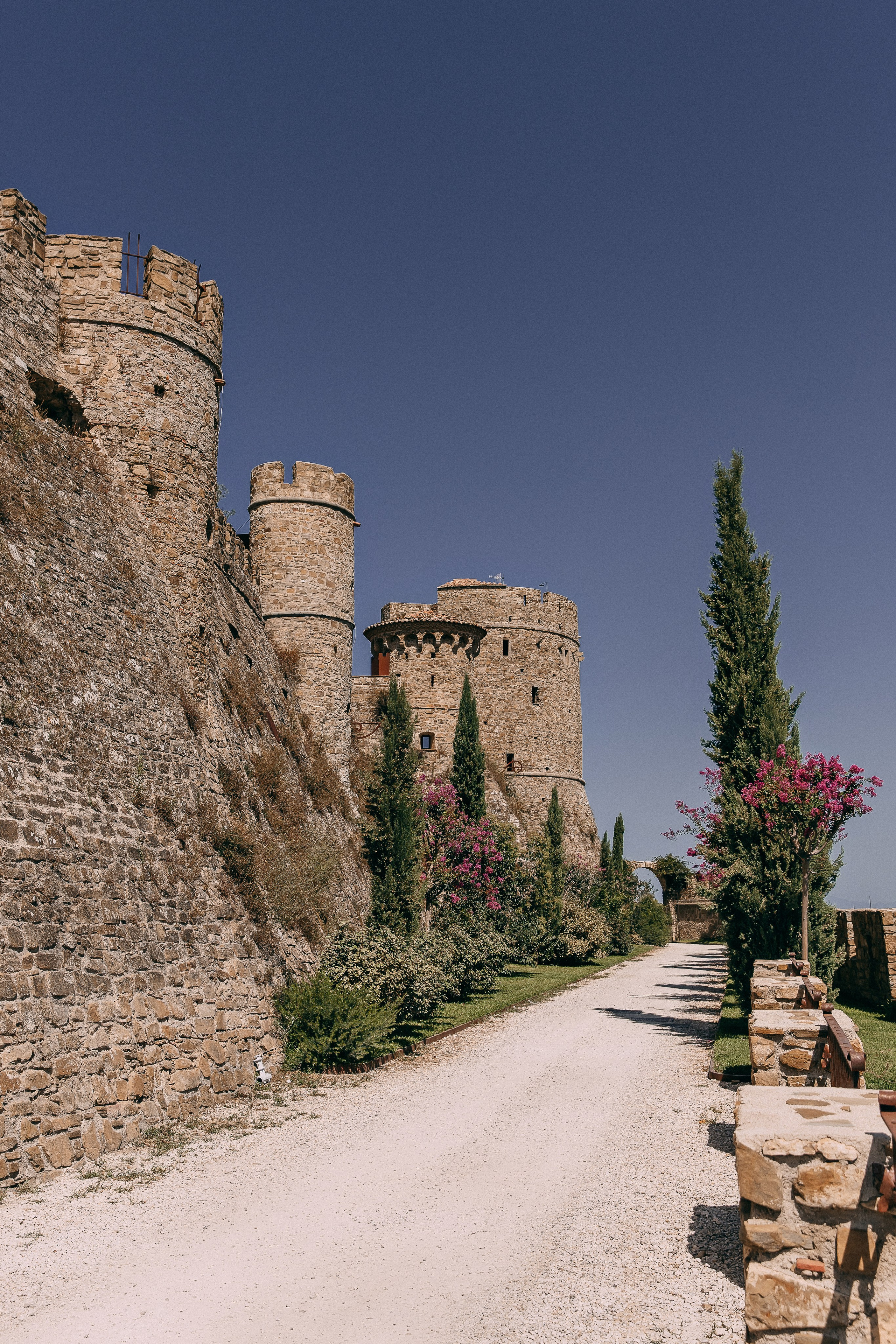 Stone towers and an oleander-lined path leading to Castello di Rocca Cilento wedding venue