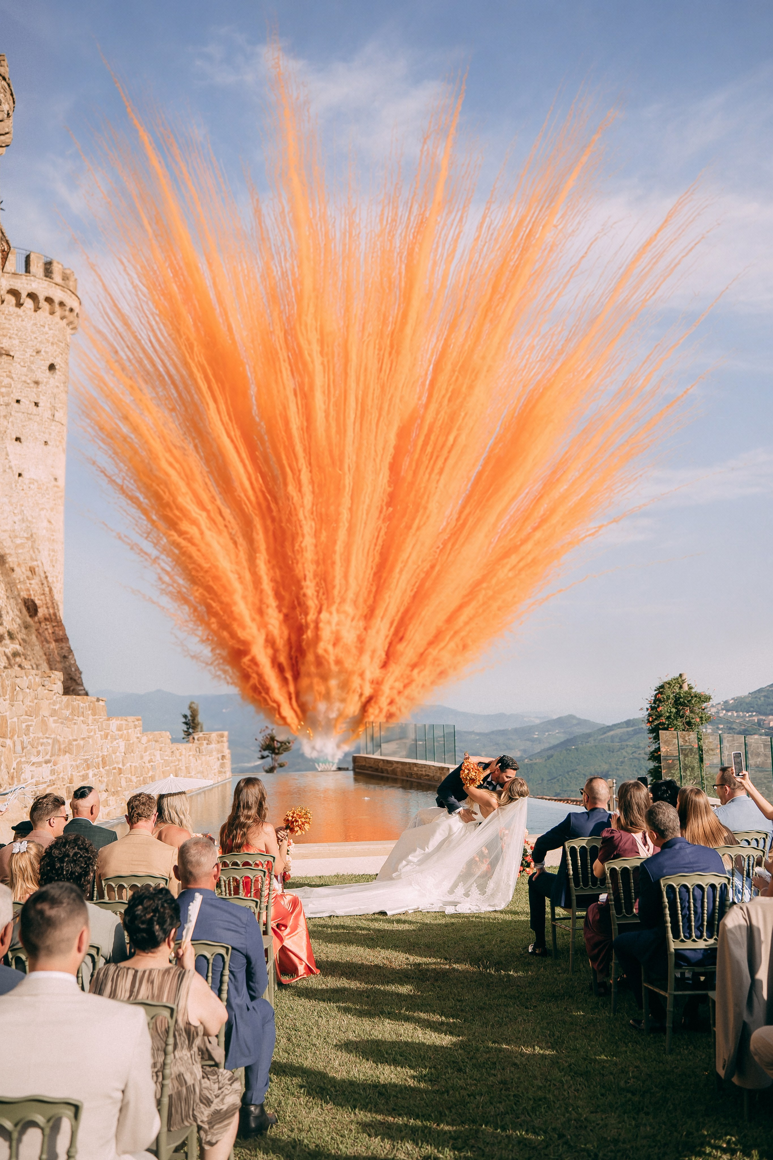 Orange smoke confetti exploding above the ceremony at the castle