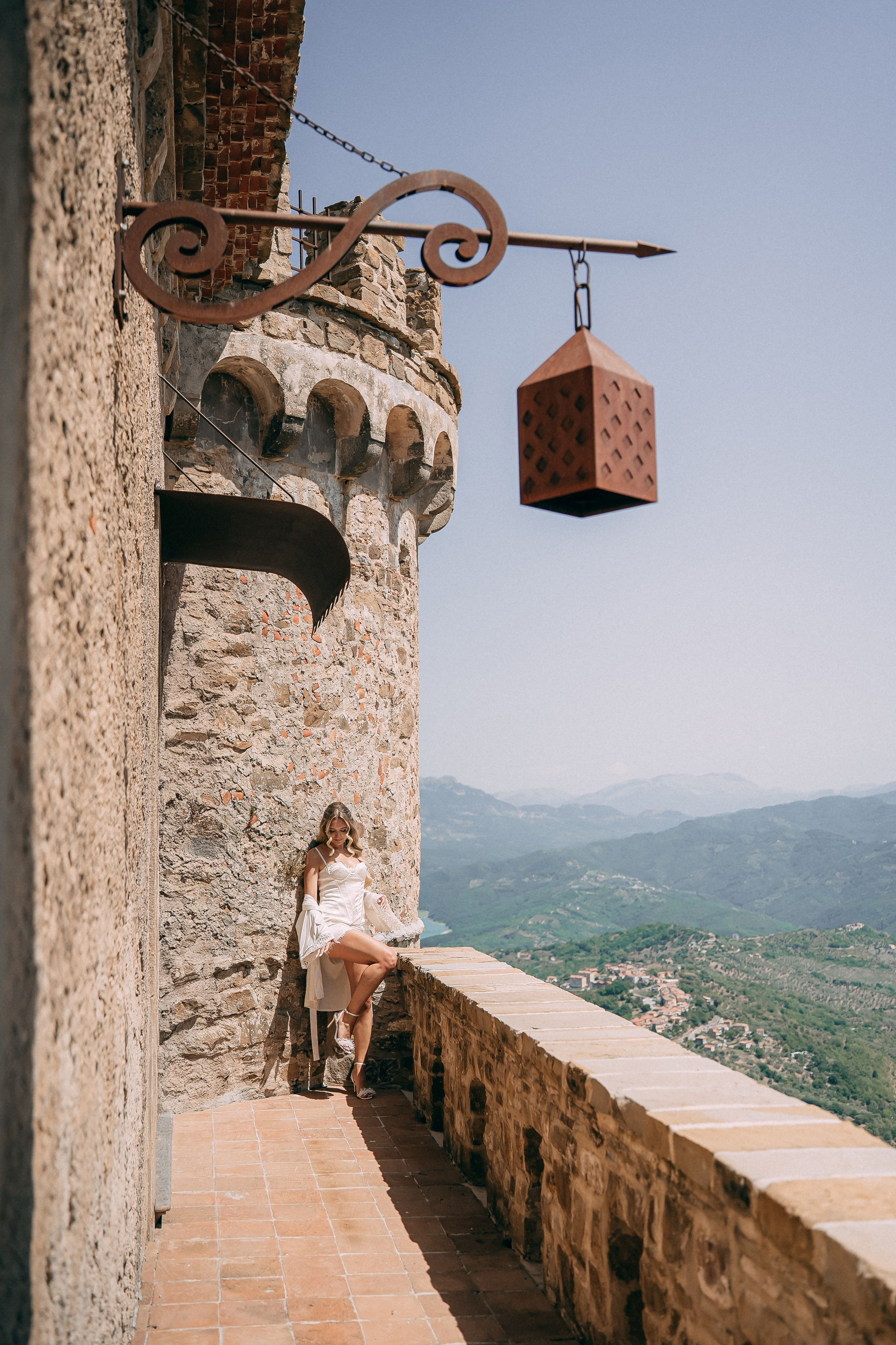 Bride resting on the castle wall beneath the medieval tower