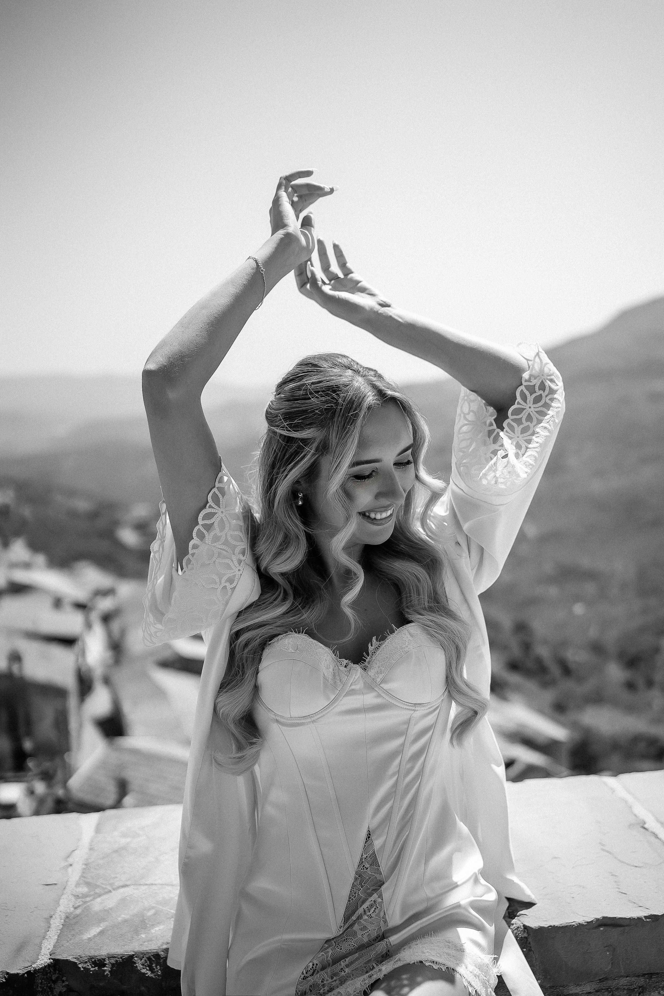 Black and white photo of the bride dancing on the terrace in the morning