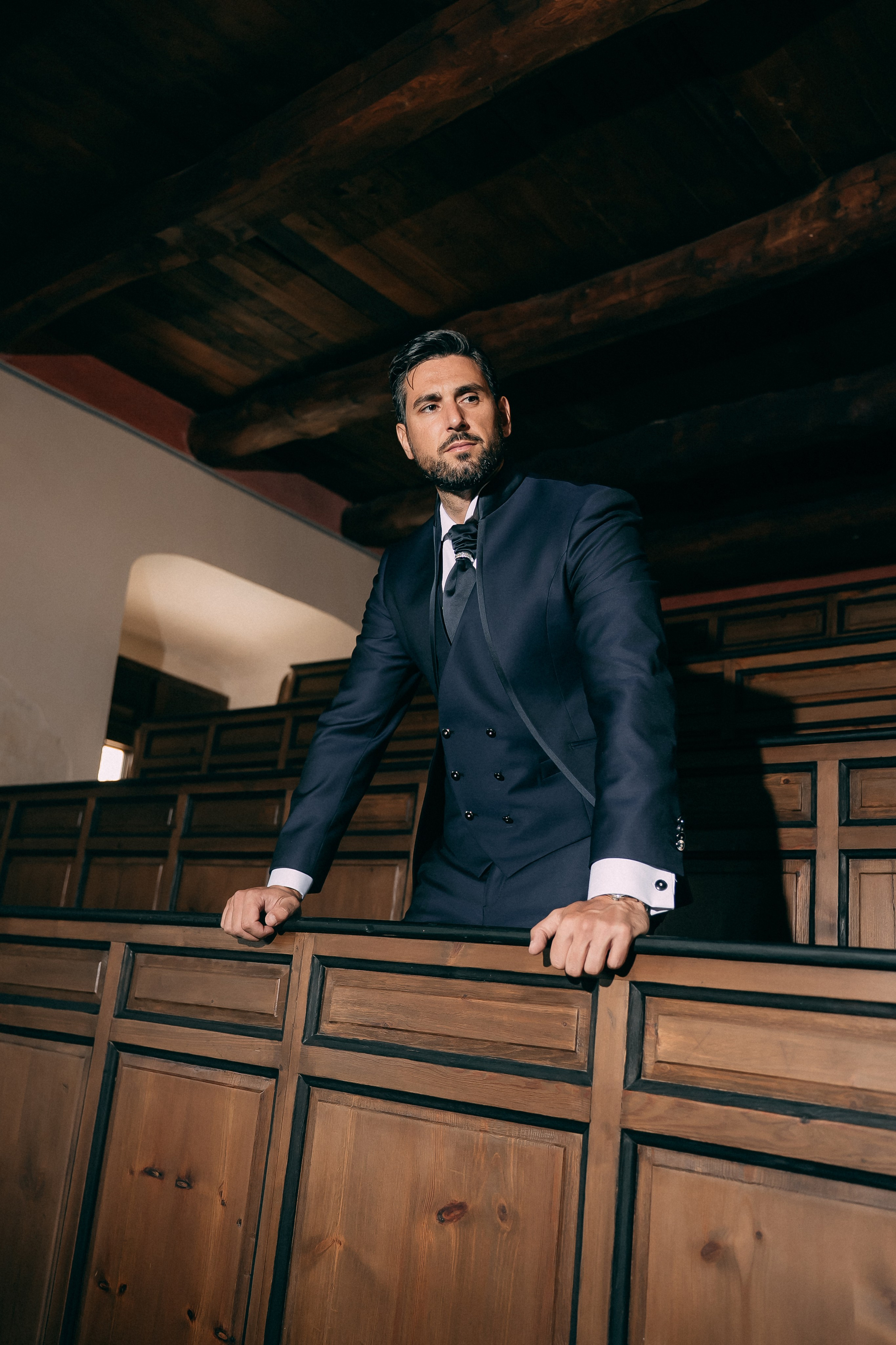 Portrait of the groom on a wooden balcony of the castle in Cilento, Italy
