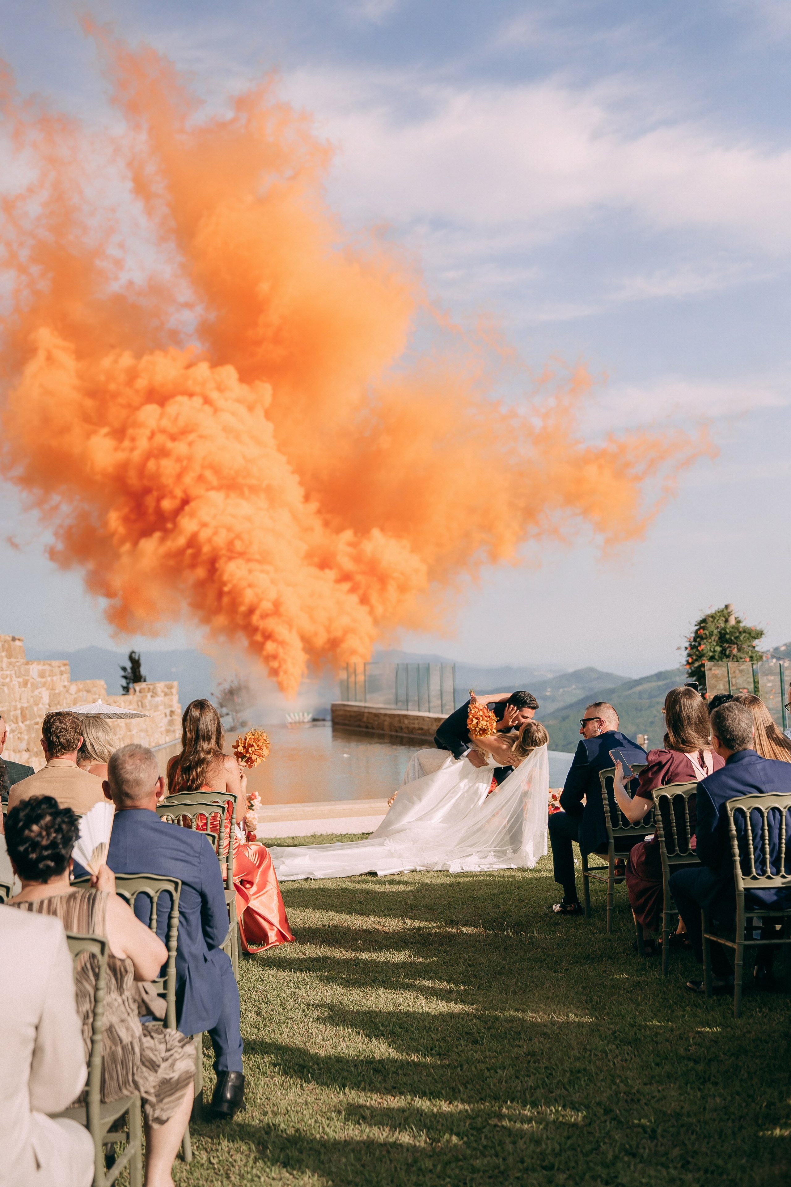 Orange smoke cannons celebrating the newlyweds after the ceremony