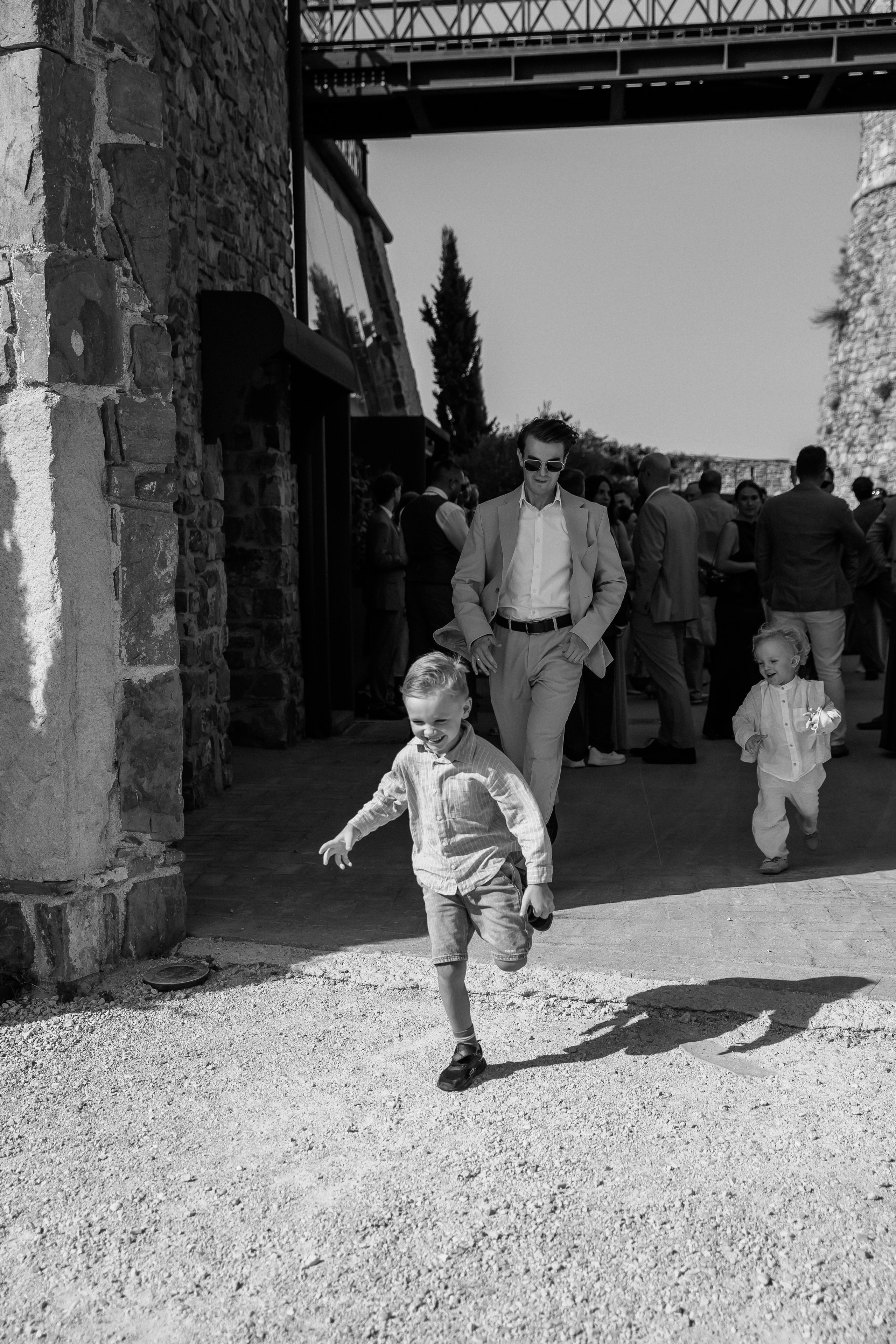 Black and white photo of children running to the ceremony at the castle