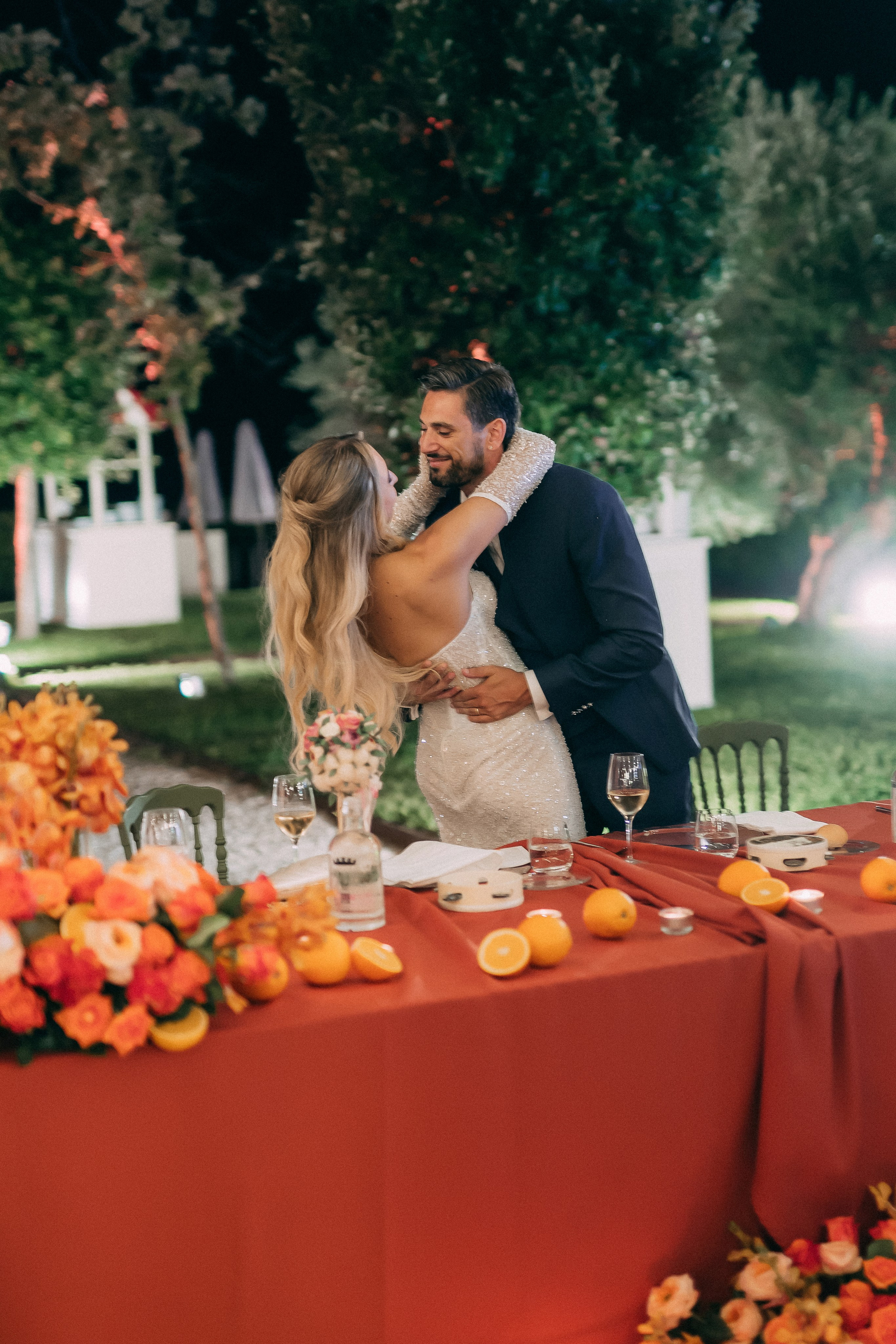 Bride and groom kissing at the head table decorated with citrus