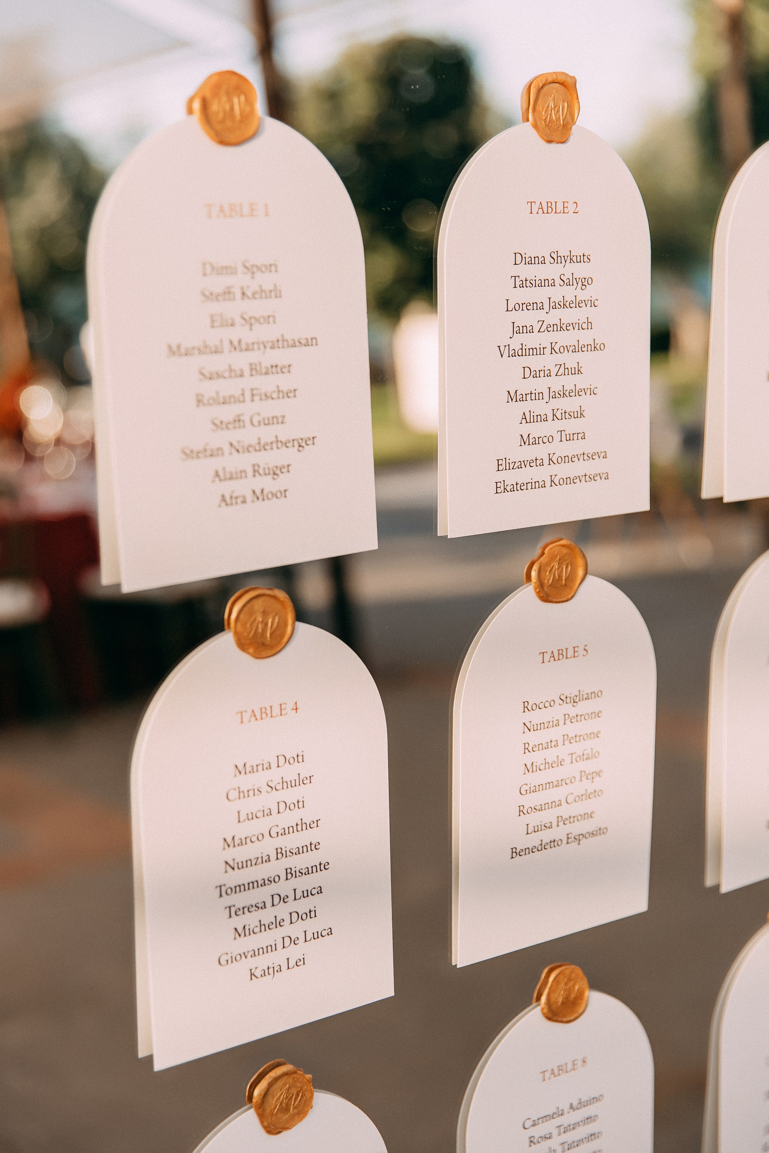Wedding seating chart with wax seals displayed in the garden