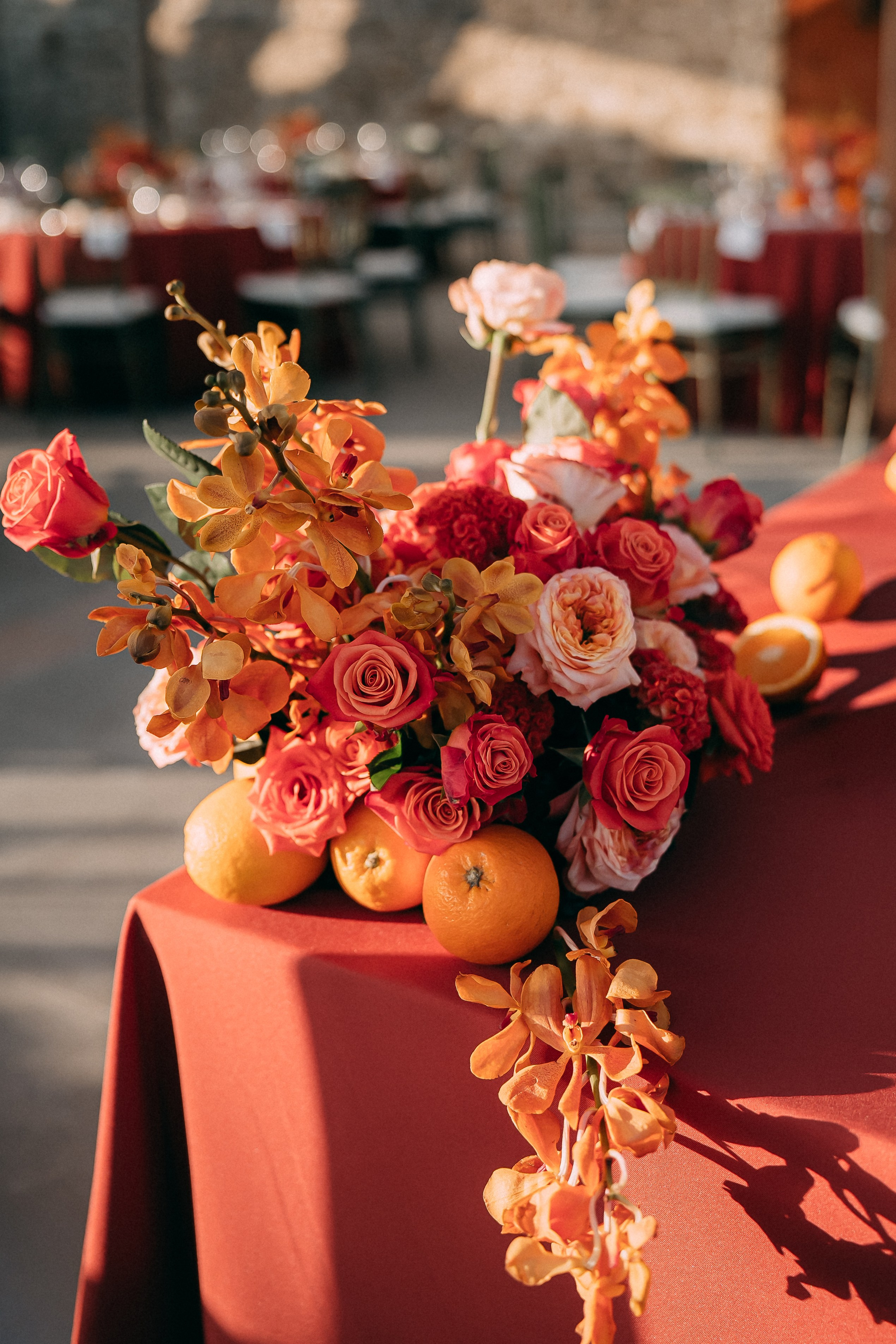 Vibrant orange and red wedding centrepiece with citrus fruit