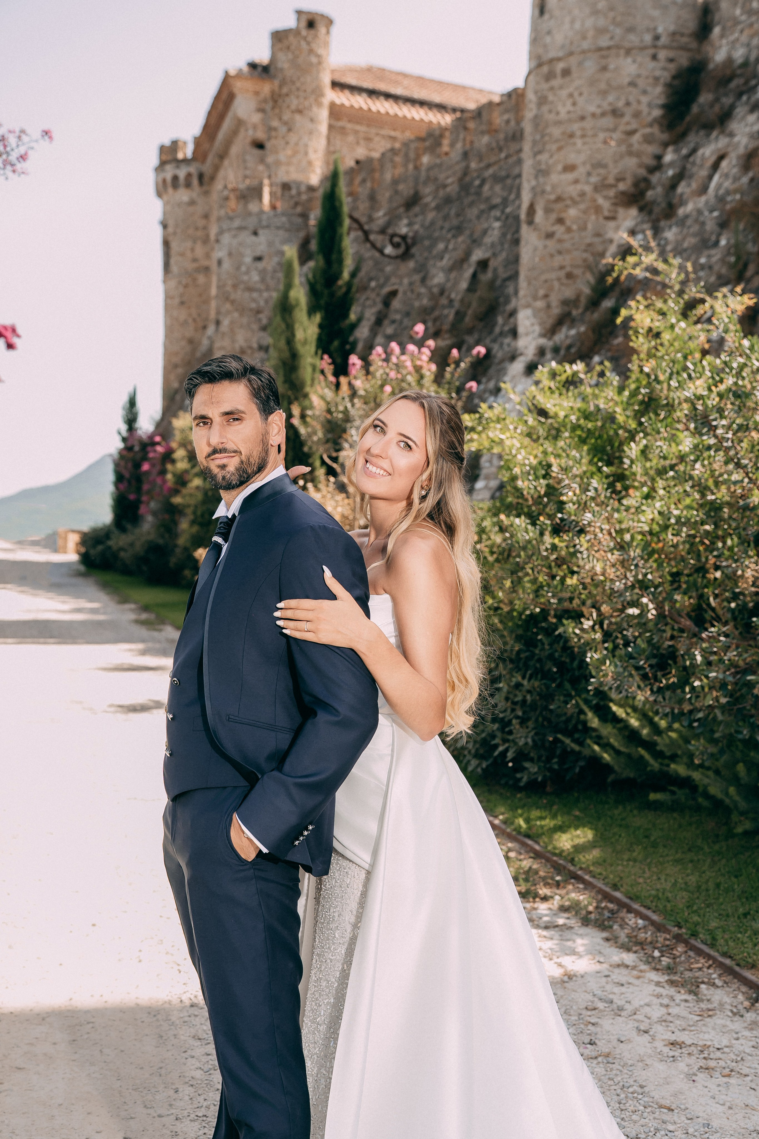 Portrait of the bride and groom on the path outside the castle
