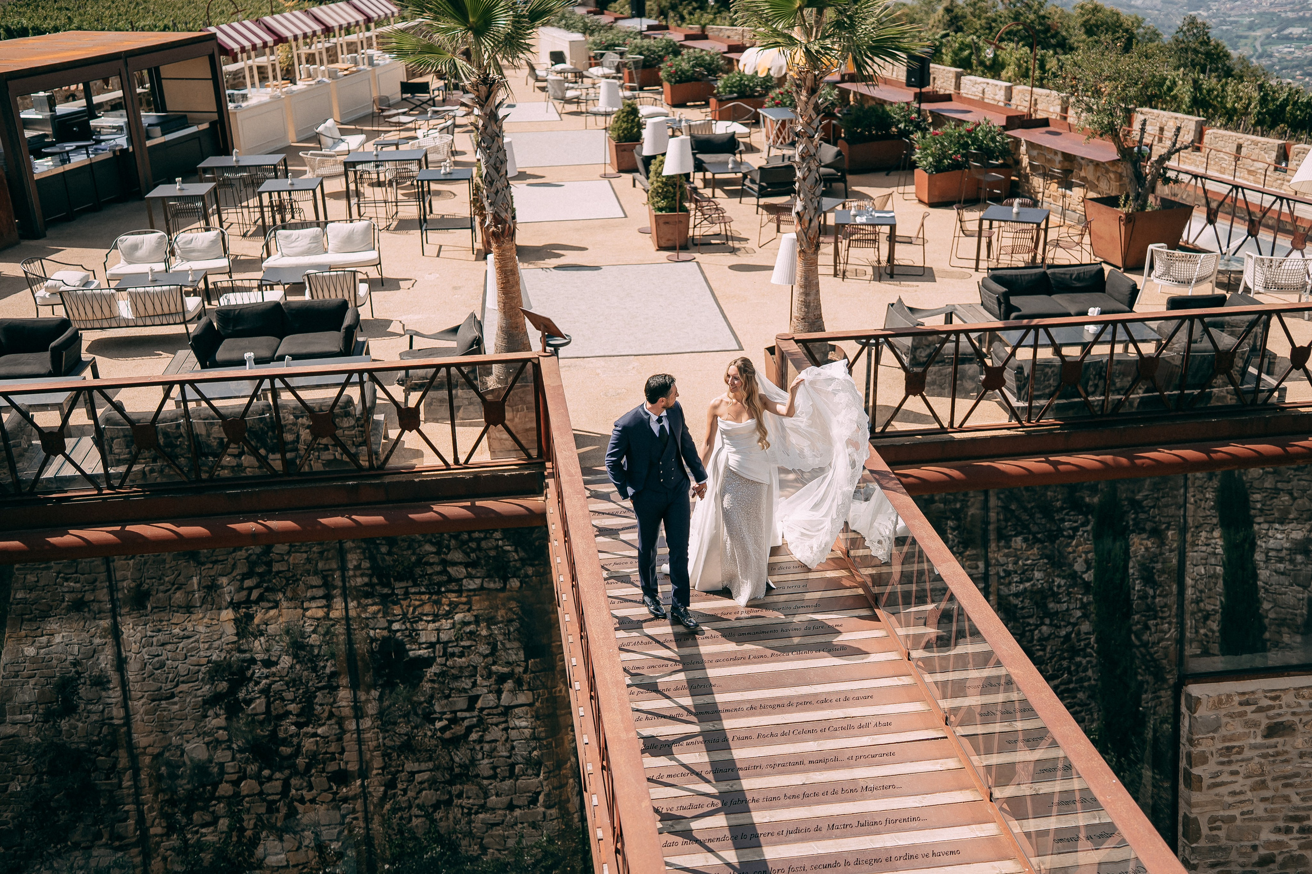 Newlyweds walking up the stairs of the castle terrace