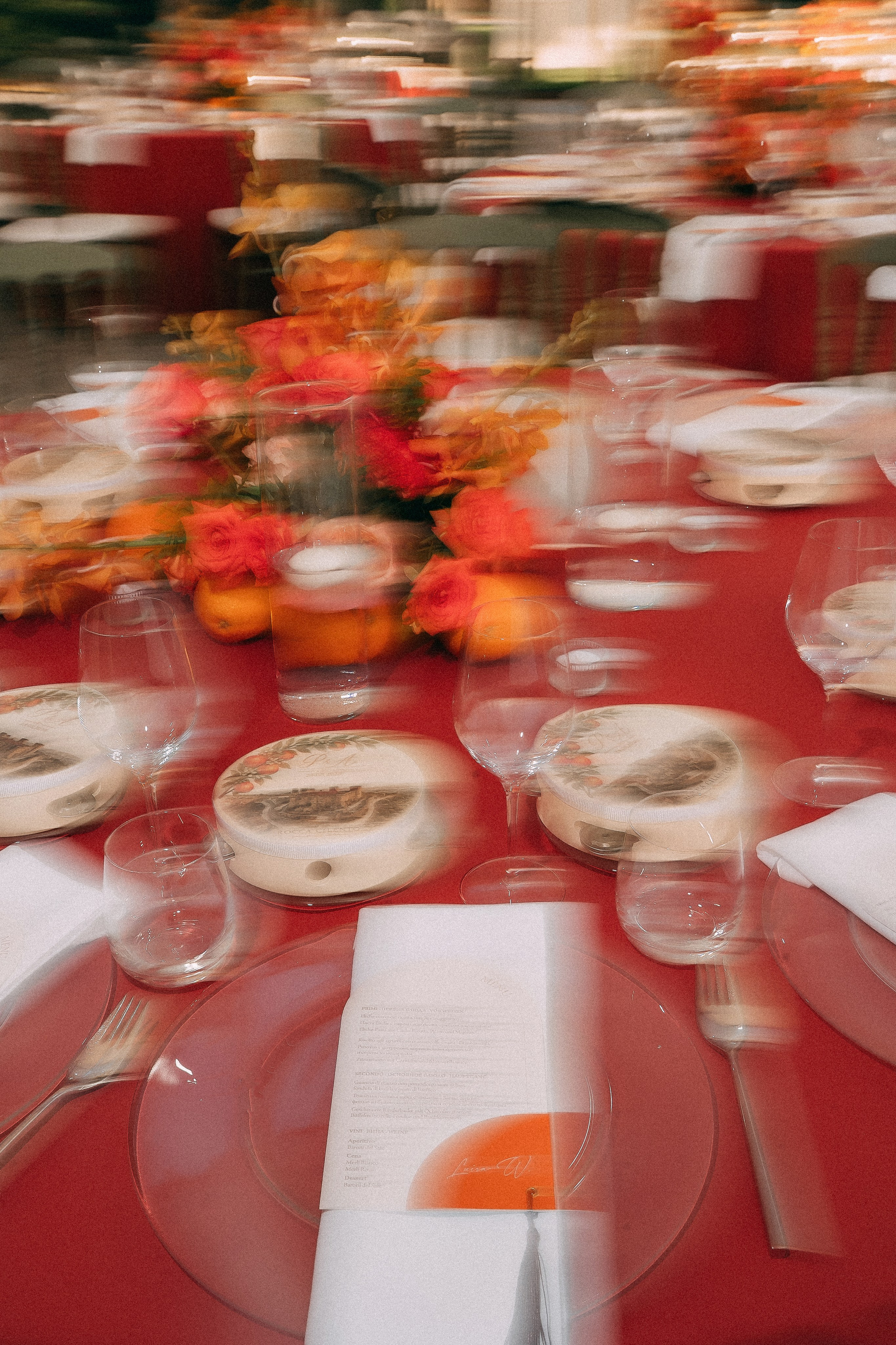 Blurred artistic shot of the reception table with orange flowers