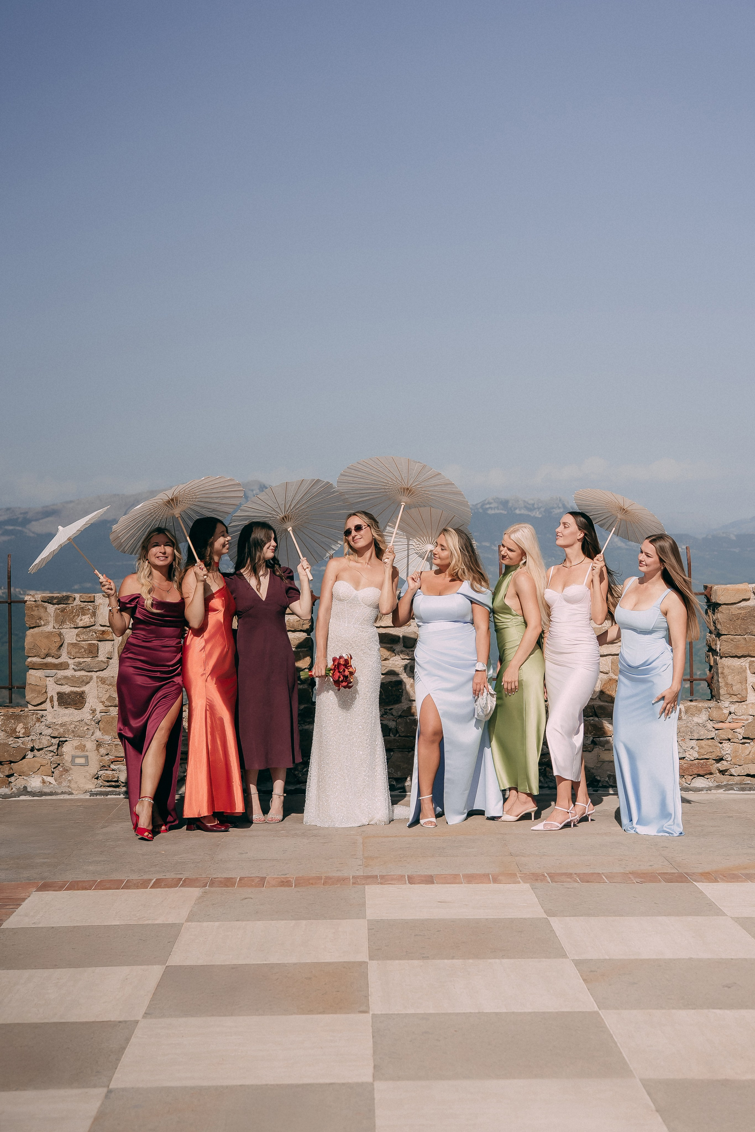 Bridesmaids posing with parasols on the castle terrace before the ceremony