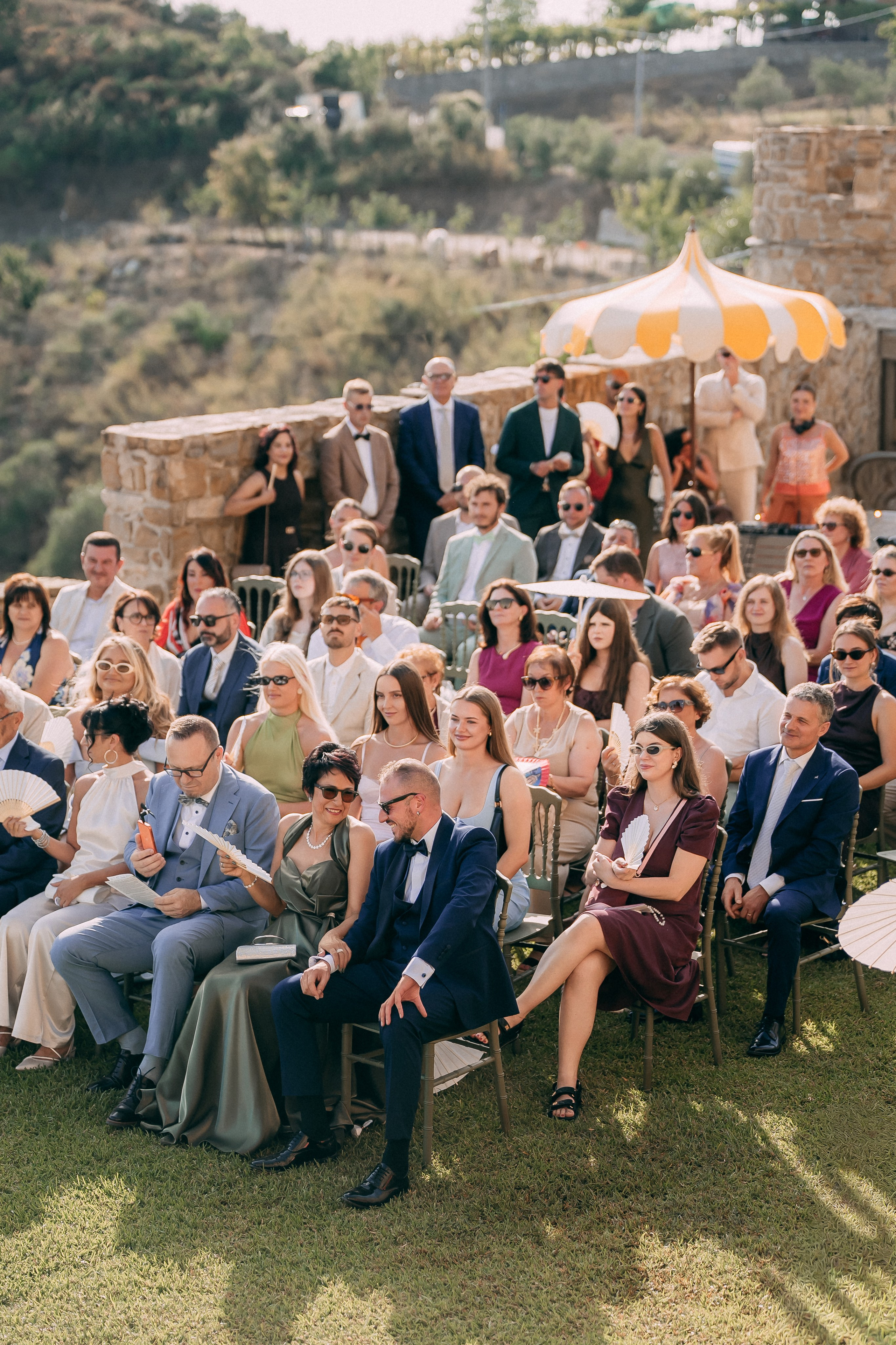 Wedding guests seated for the ceremony with a view over the hills
