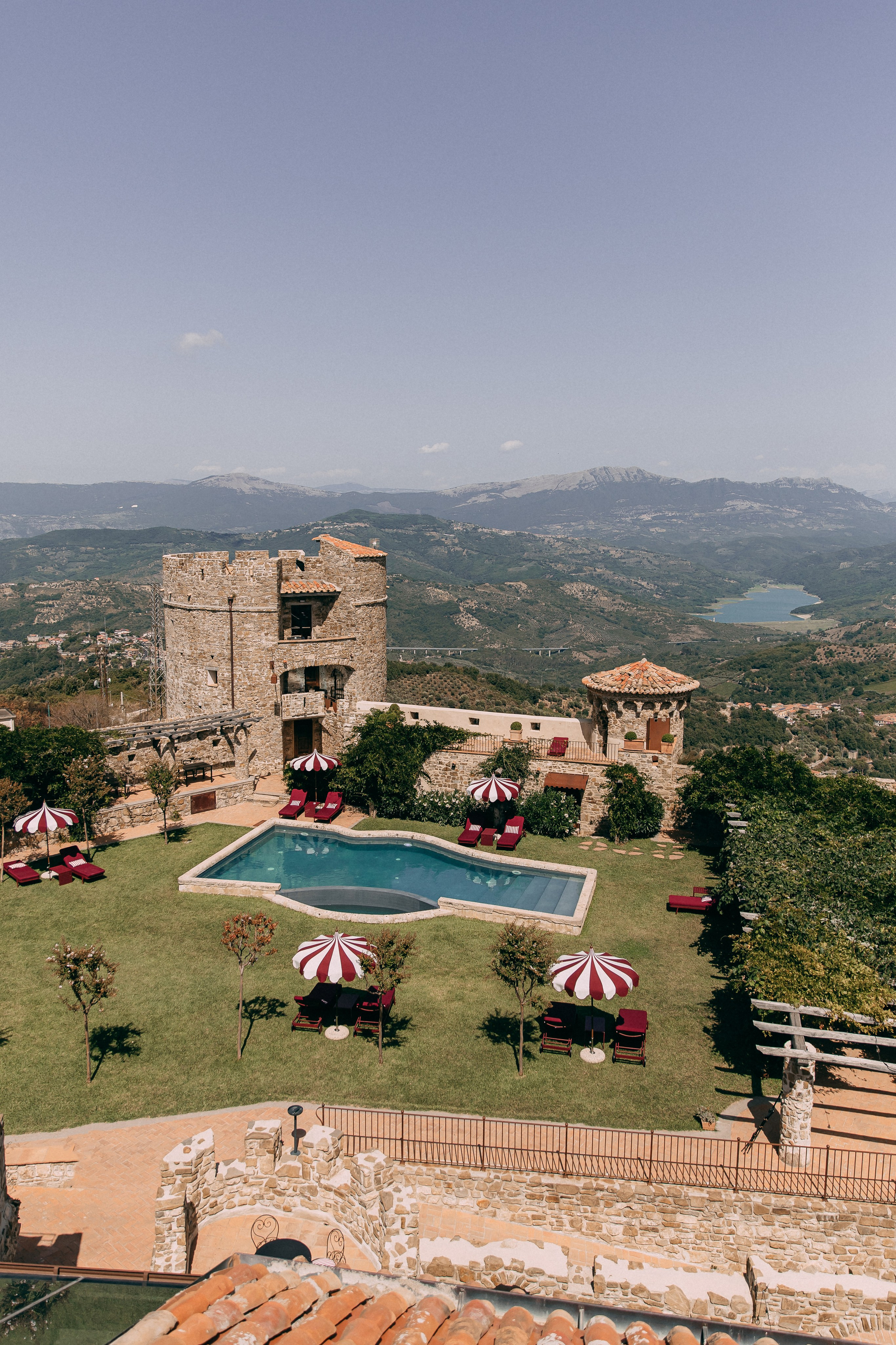 View of the castle tower, pool and gardens of the wedding venue in Italy