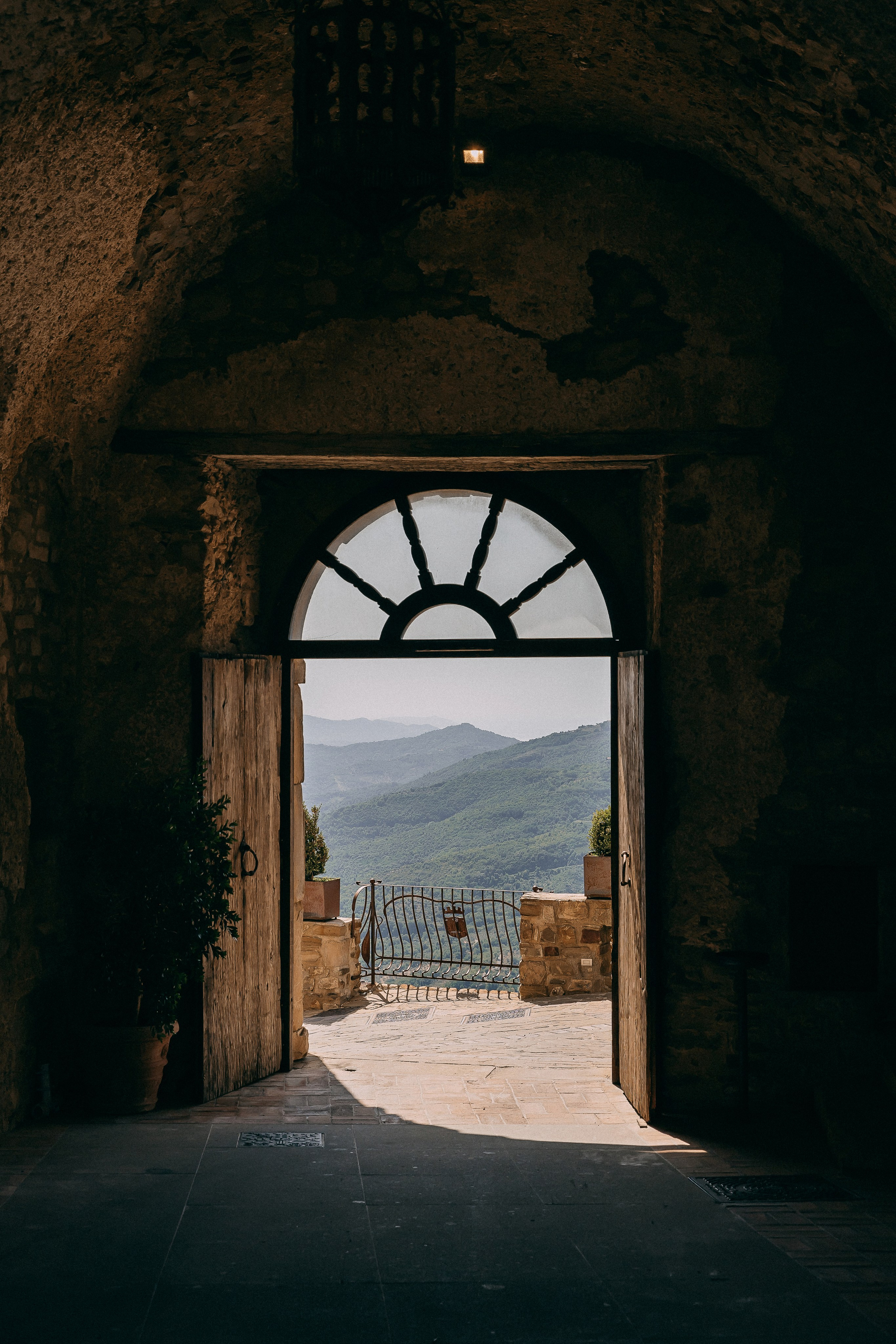 Open wooden castle door framing the green hills of the Amalfi Coast hinterland