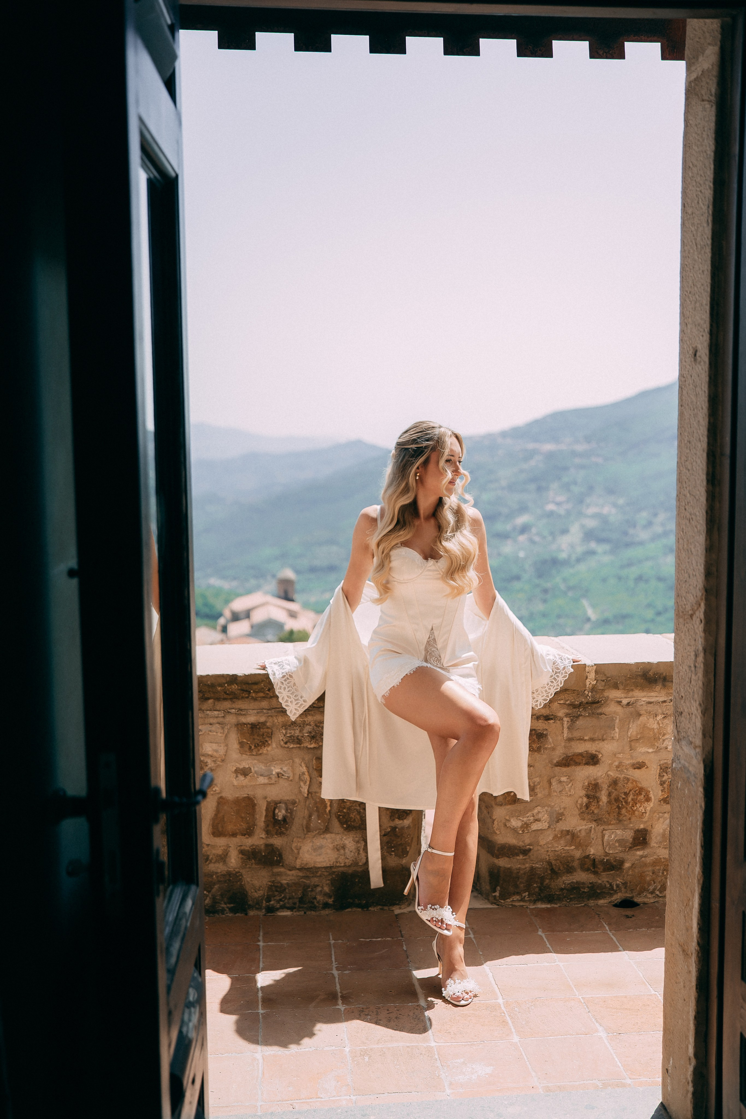 Bride laughing in a doorway of the castle tower before getting dressed