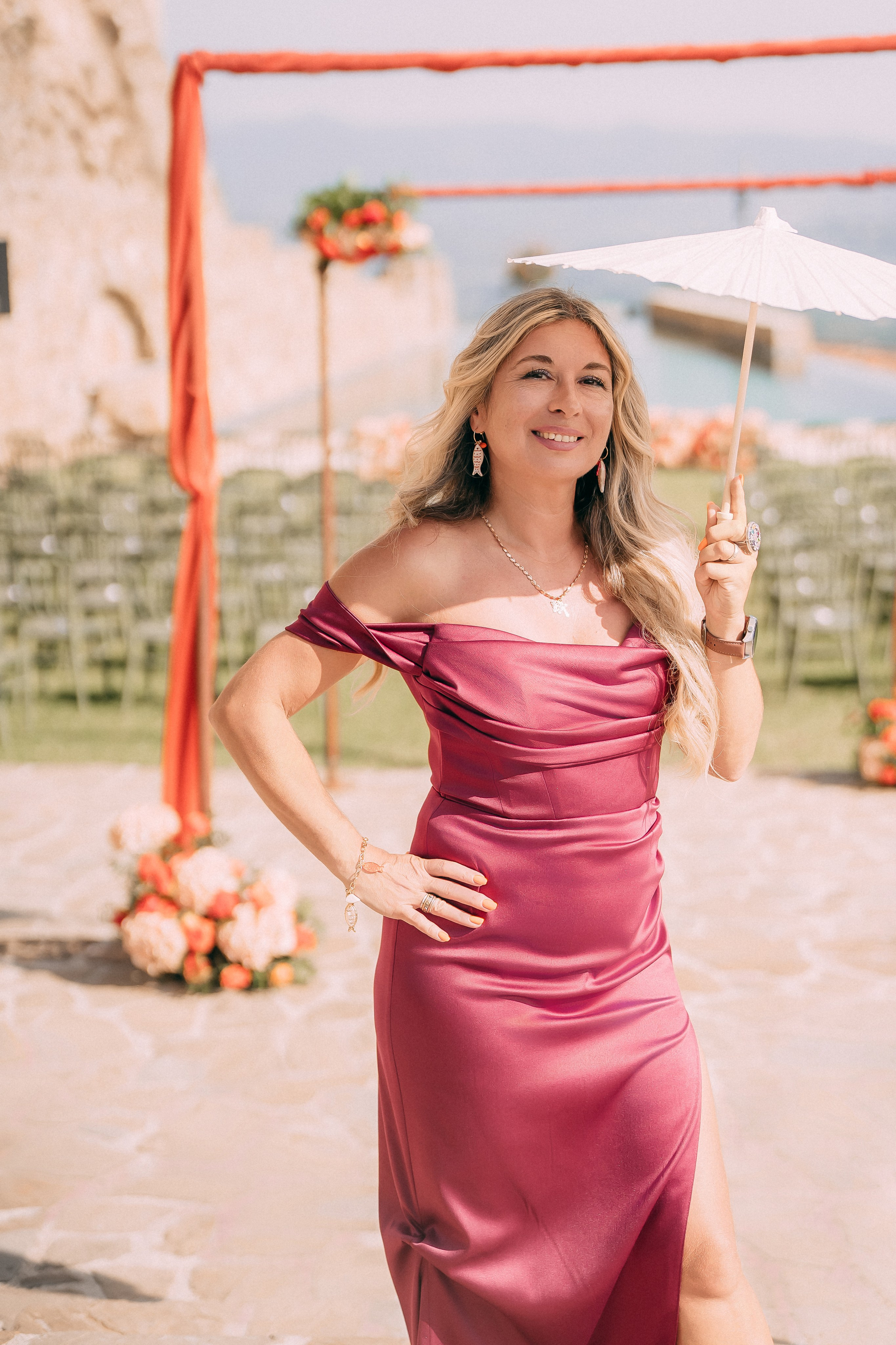 Guest in a raspberry satin dress at the wedding ceremony in Italy