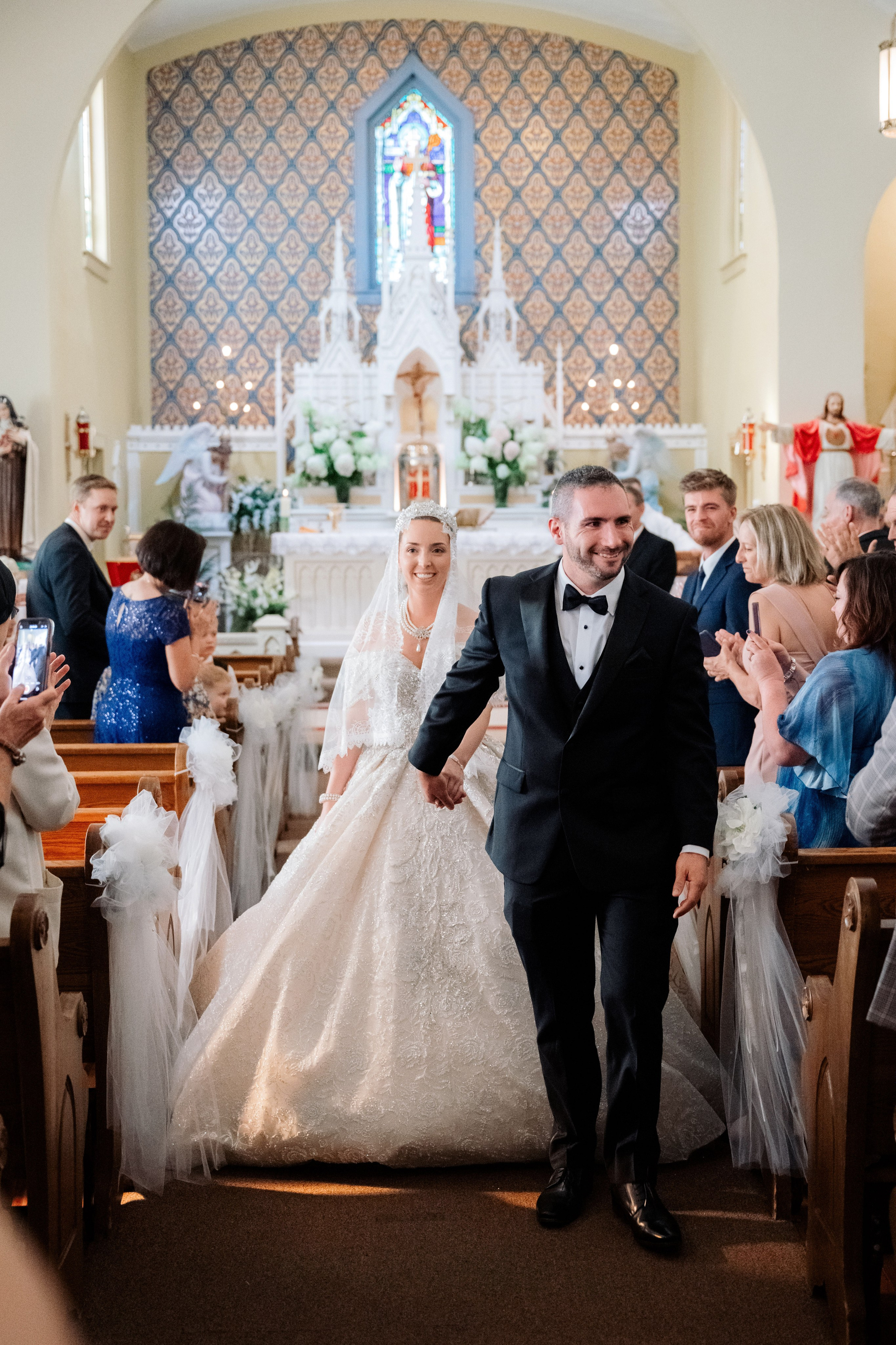 a bride and groom walk down the aisle