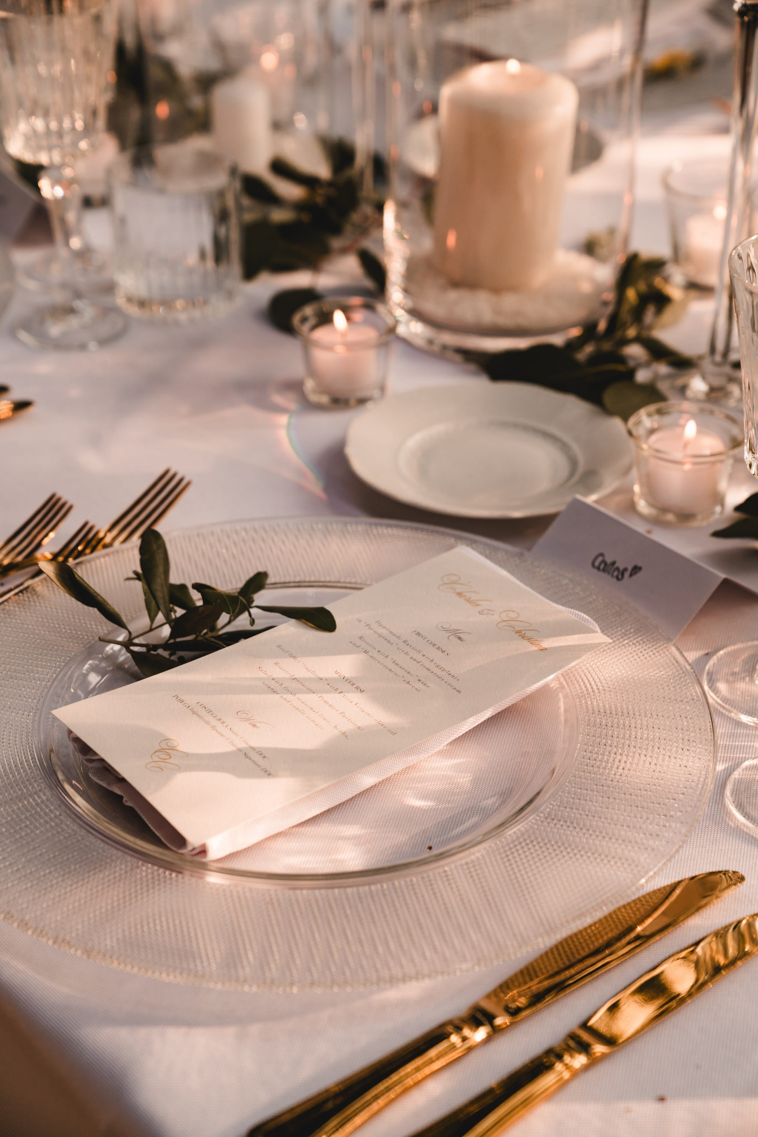 Mesa de casamento decorada com velas, louça elegante e folhagem — detalhe de styling sofisticado.