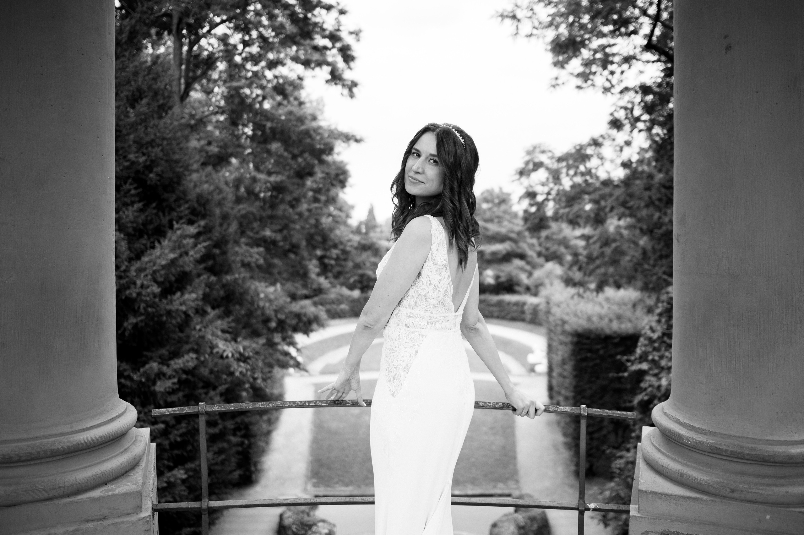 Braut im Hochzeitskleid zwischen Säulen im Schlossgarten Schwetzingen