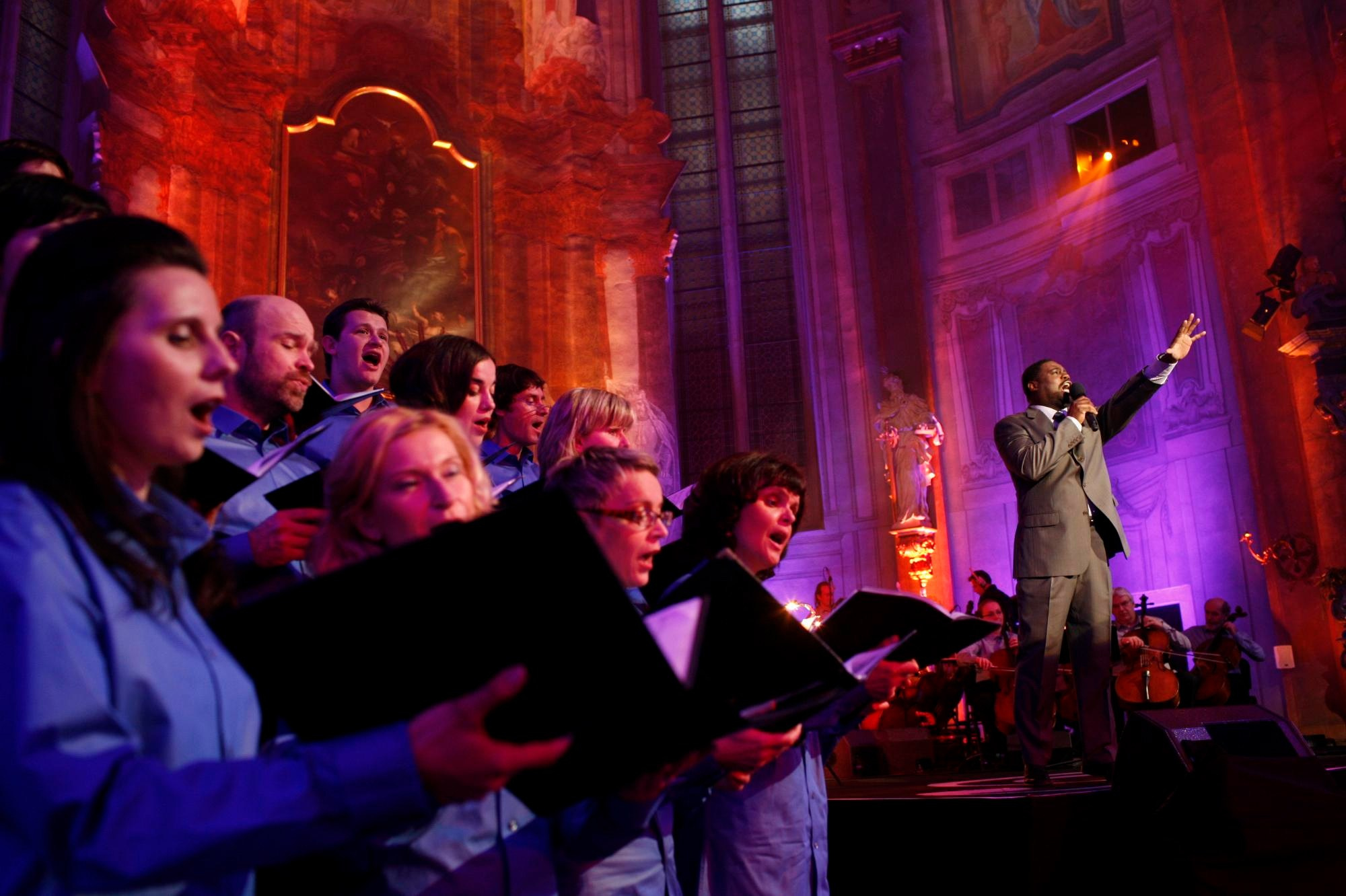 A singer performs with the backing of a choir group during a made-for-television production in Prague.