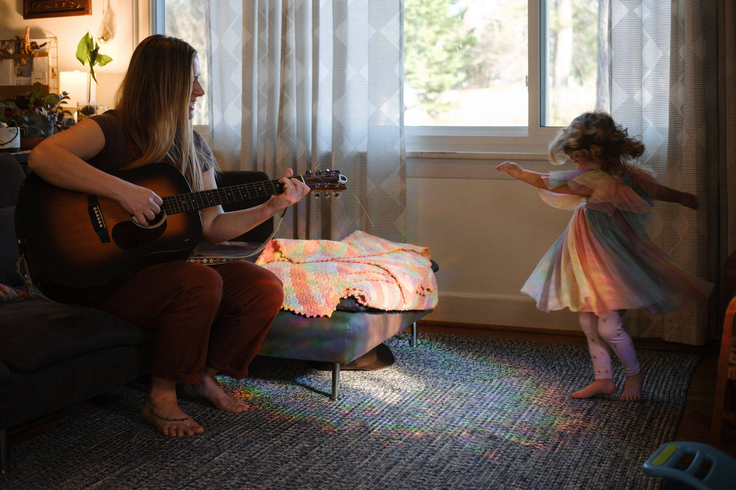 Authentic family session in Richmond, Virginia, featuring children playing with toys on the floor while parents look on with genuine smiles.