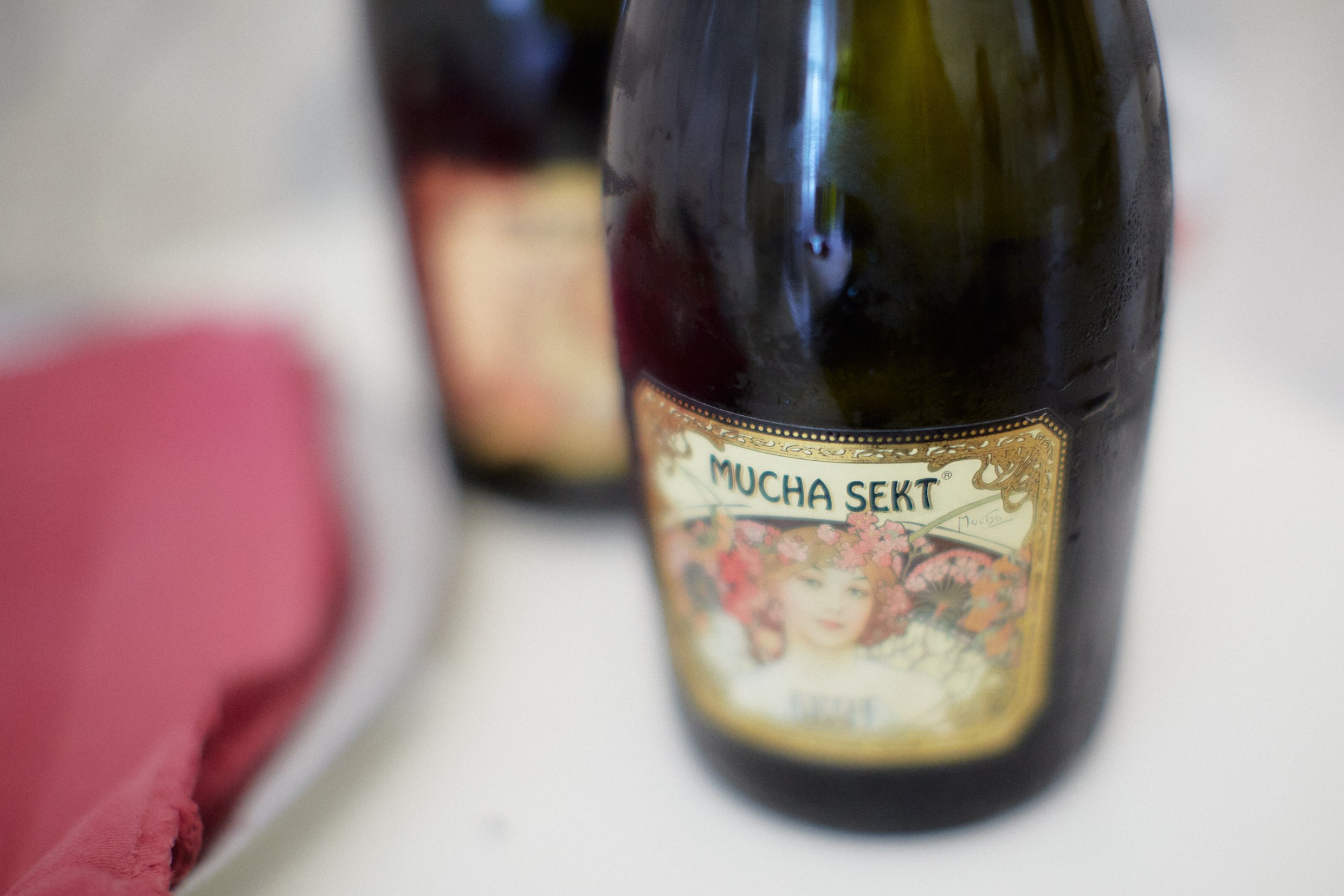 Alfons Mucha-inspired champagne bottles in moody bridal suite.