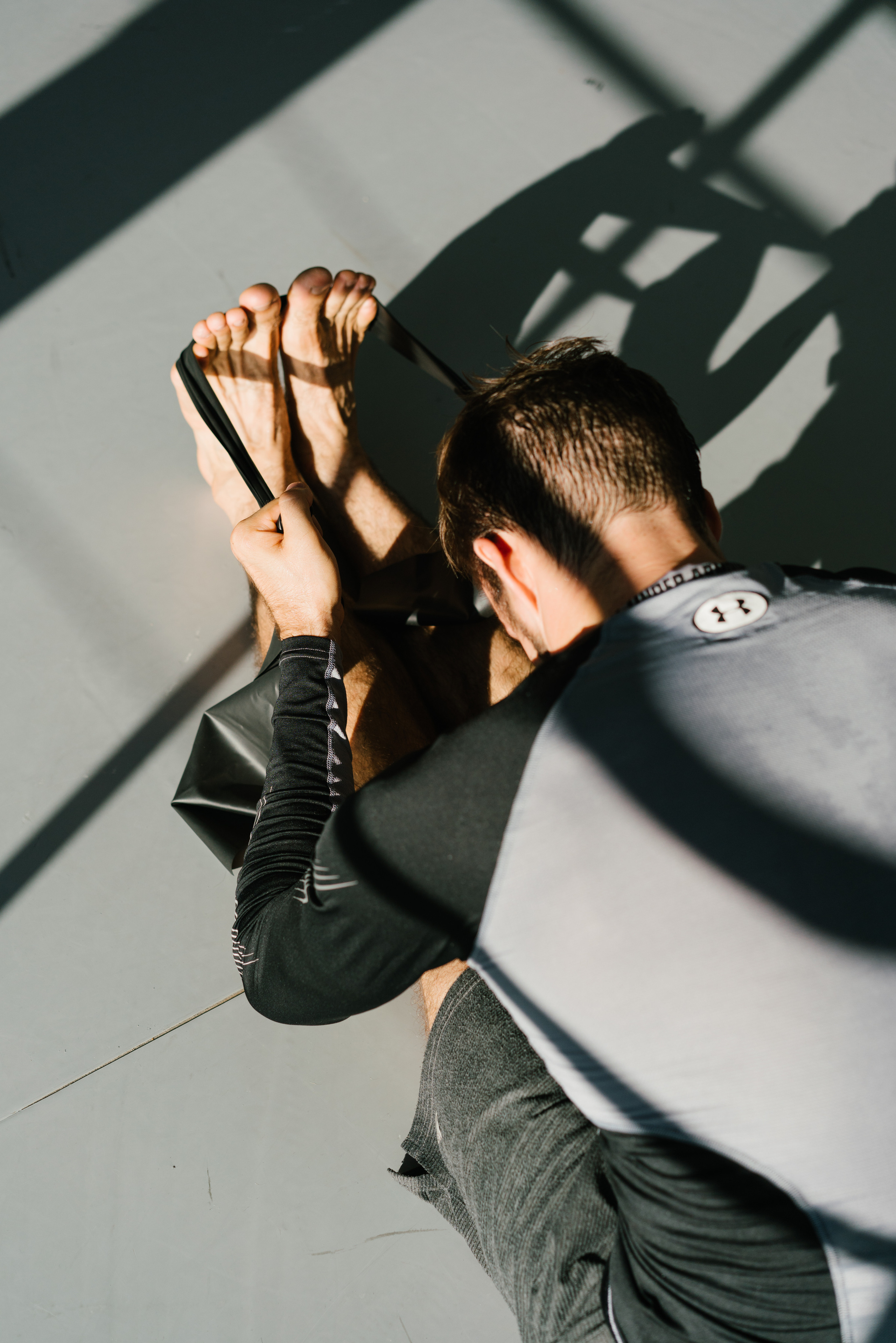 Man doing stretching with belt on the floor