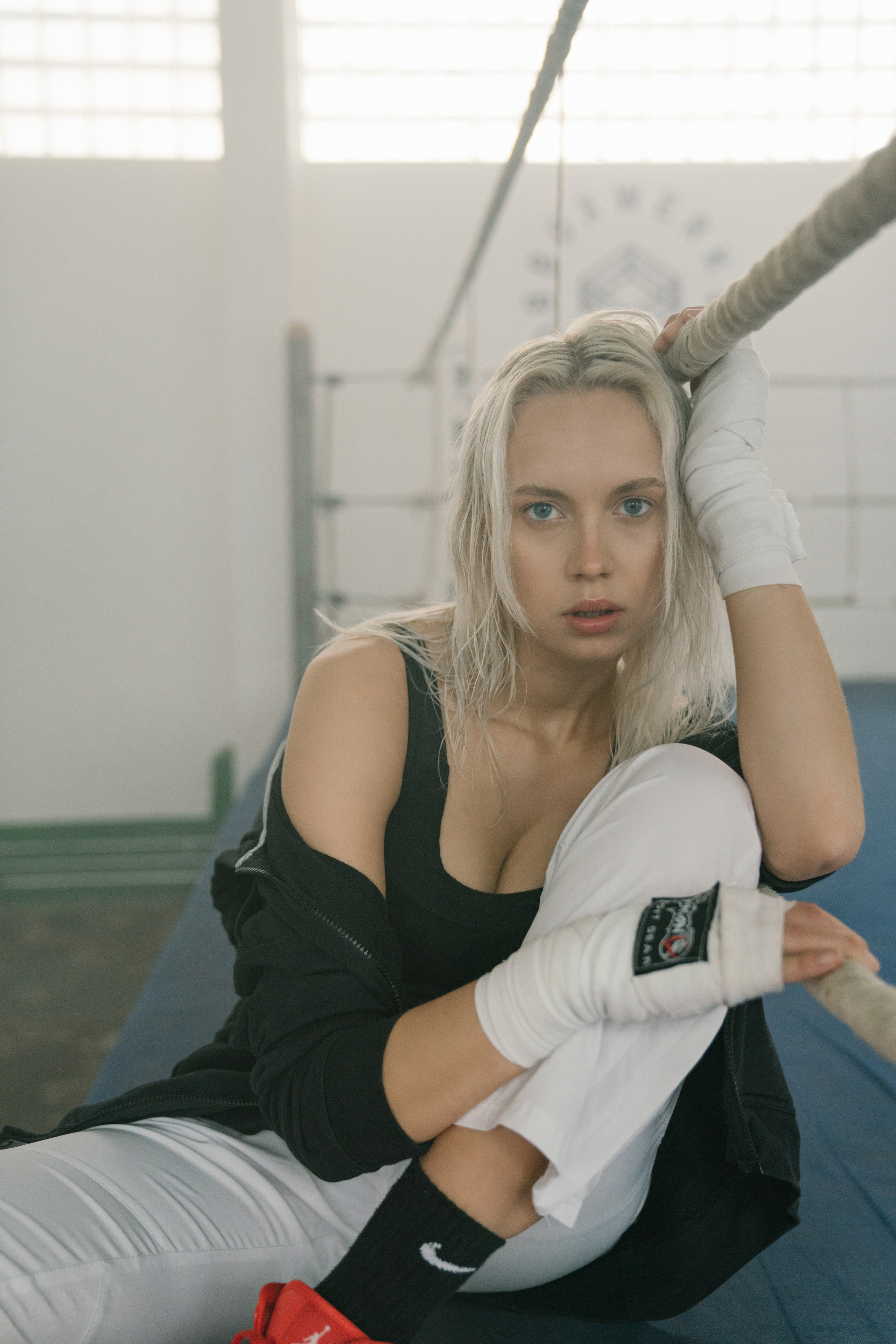 Woman in warm clothes is resting on the boxing ring