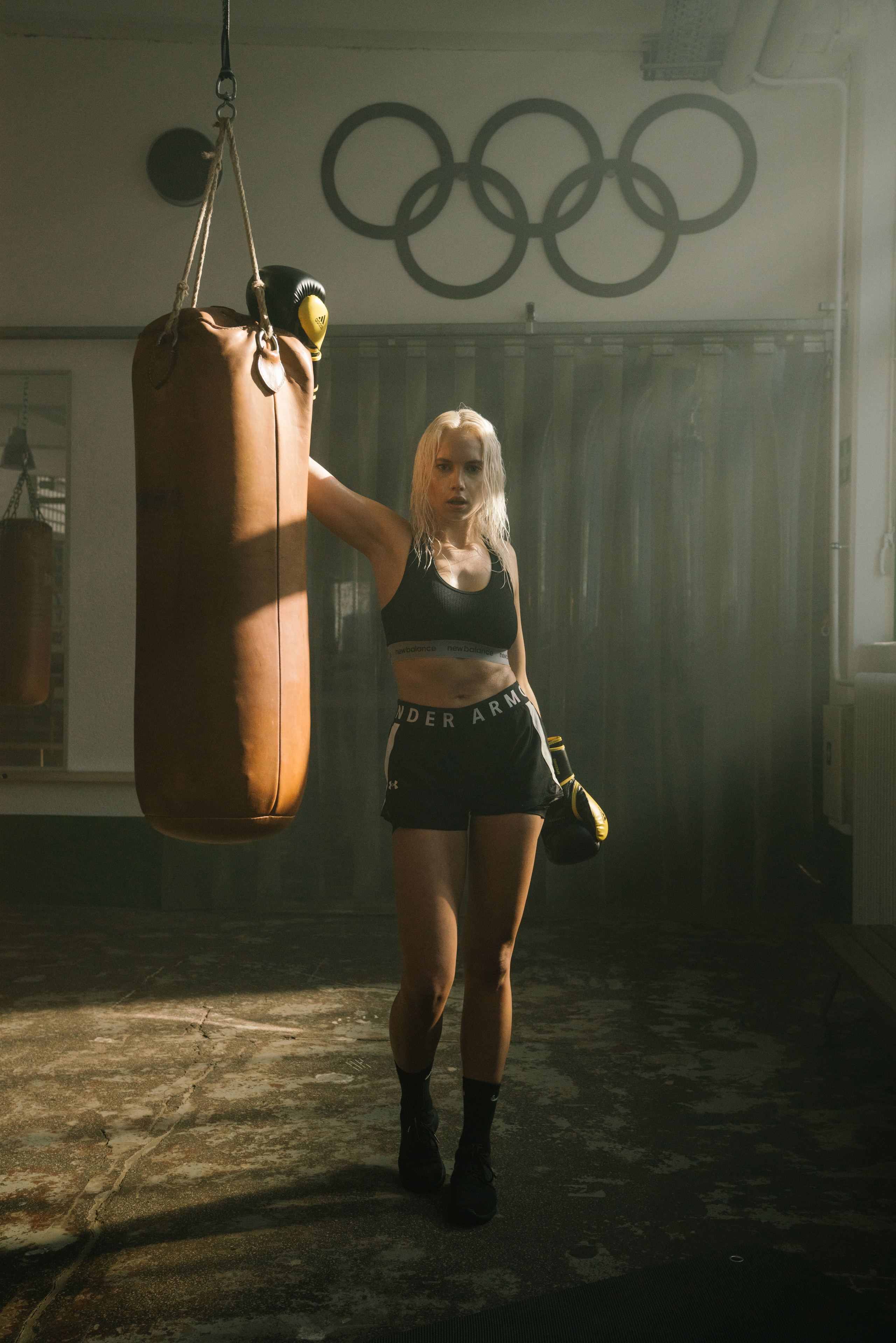 Along woman in boxing gloves in a olympic hall
