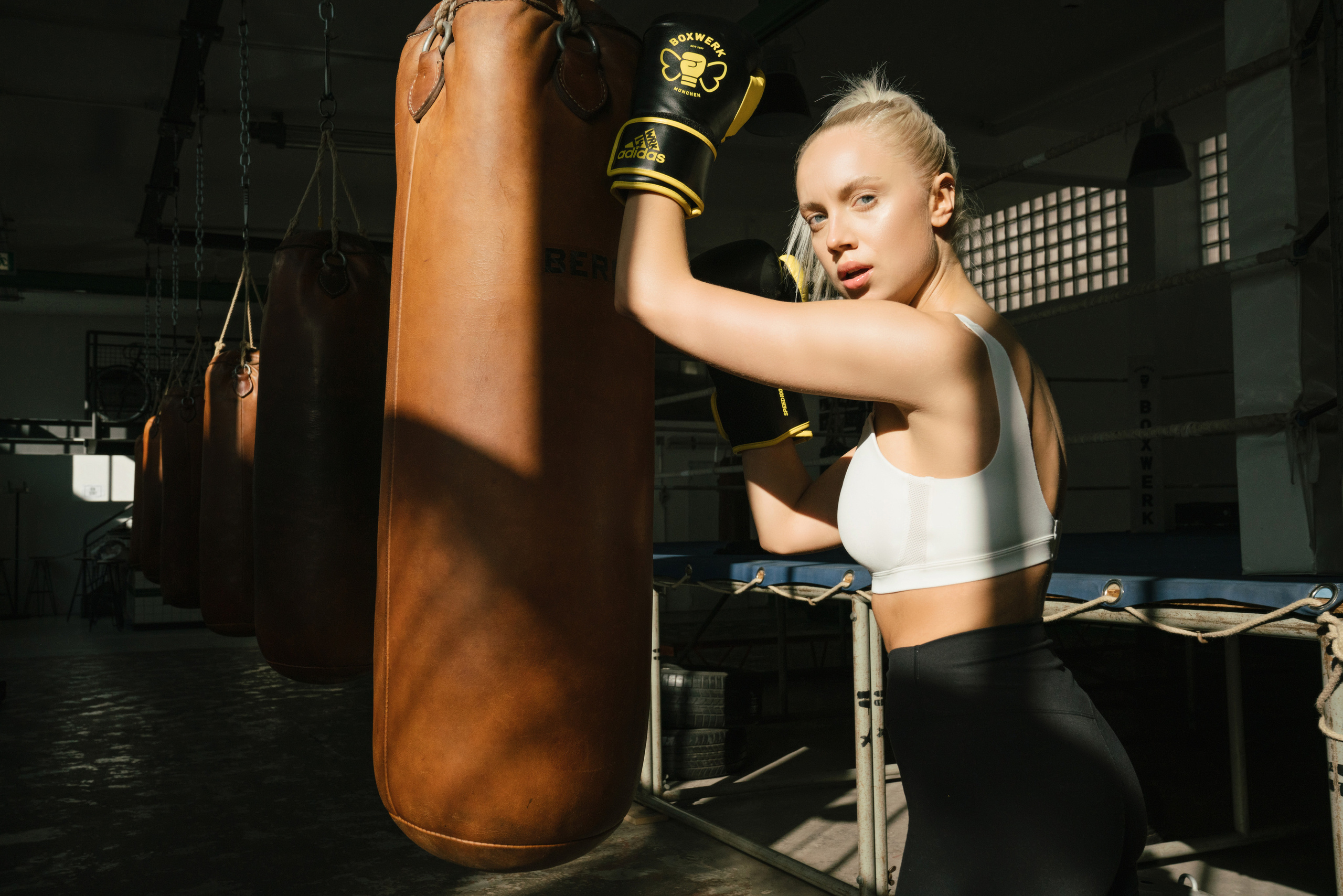 female boxer looking to the camera holding punching bag
