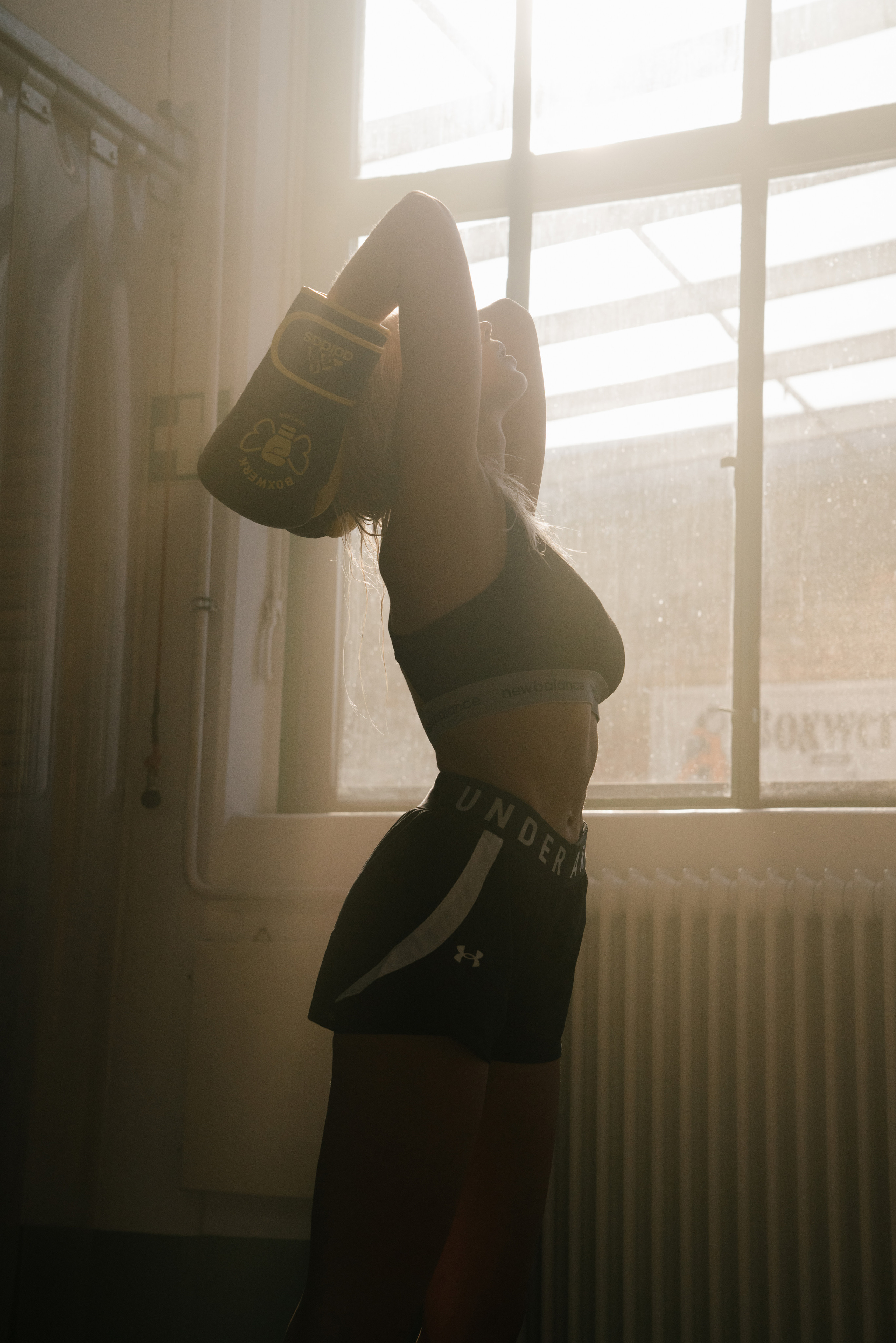 Woman is stretching in a boxing clothes in a beautiful warm and soft light