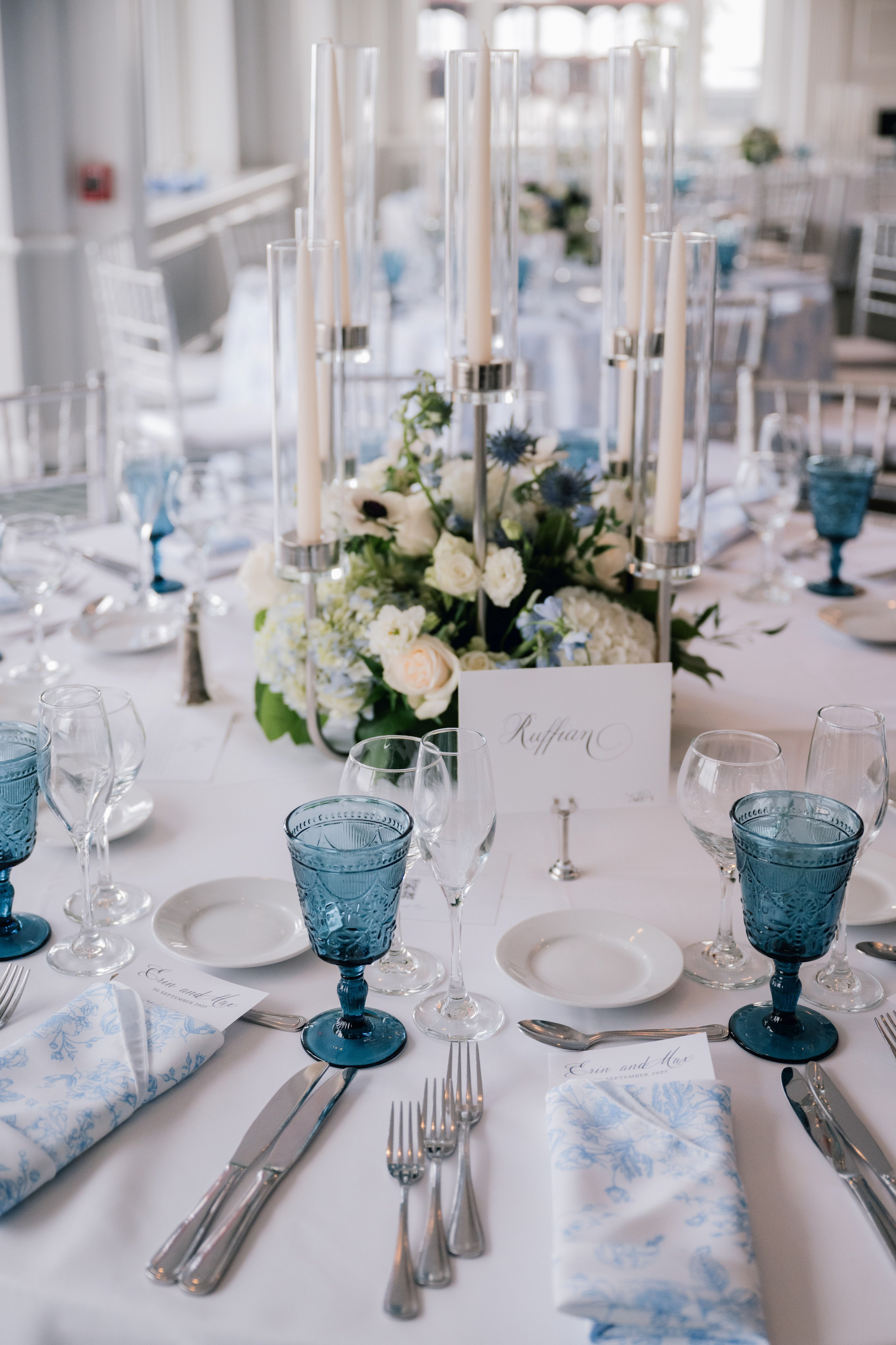 a table with a white table cloth and blue place settings