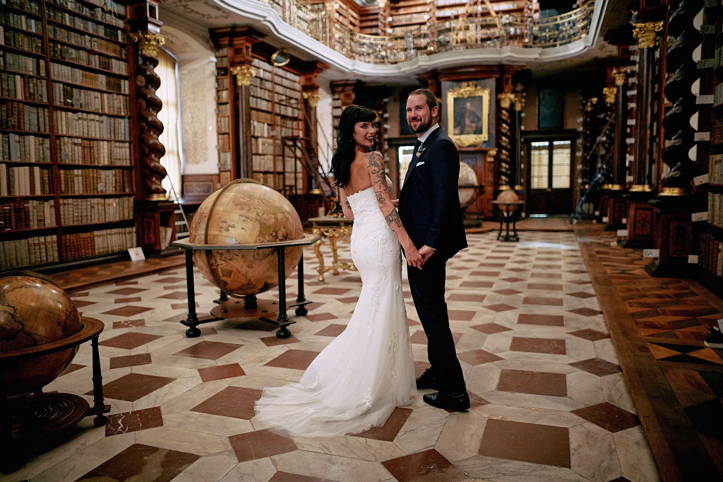 Courtney and Dean looking over shoulder in historic Baroque Library portrait.
