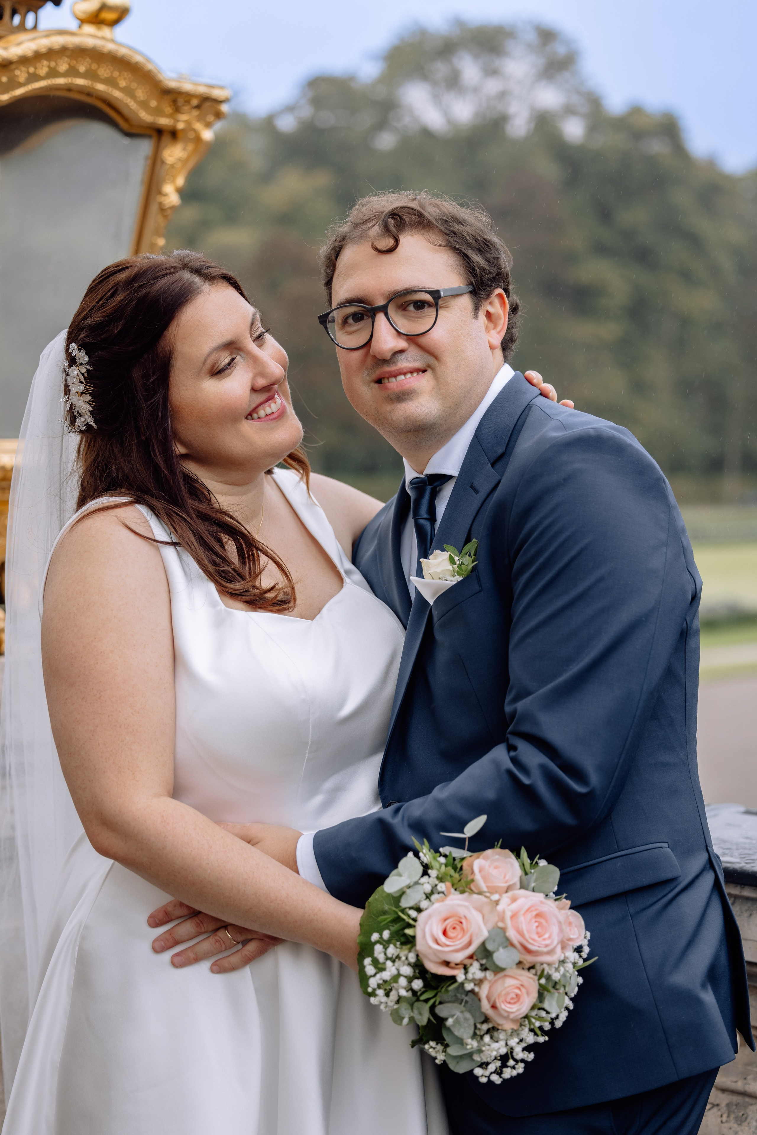 Braut und Bräutigam lachen zusammen vor dem Schloss Nymphenburg