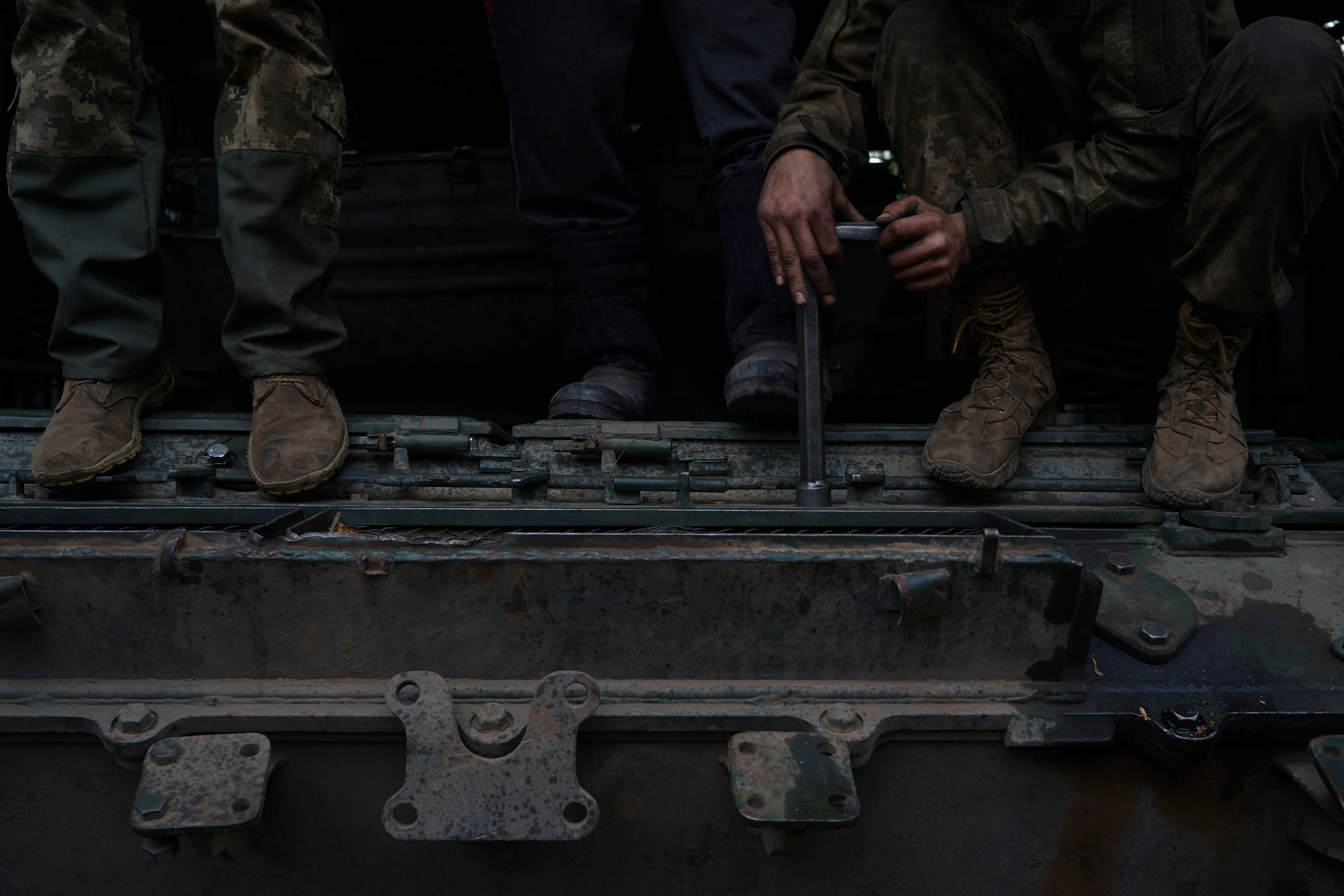 Soldiers of tank repair company fixing tank.