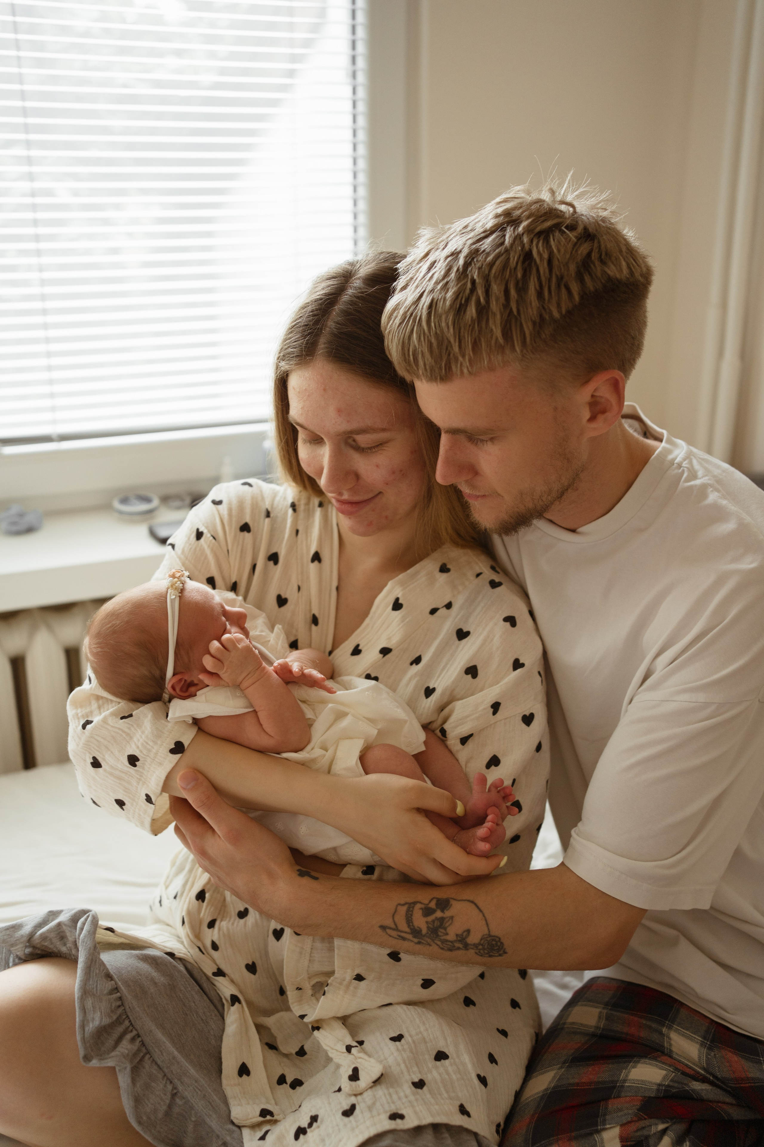 Mama i tata całujący główkę dziecka – domowa sesja rodzinna Łódź