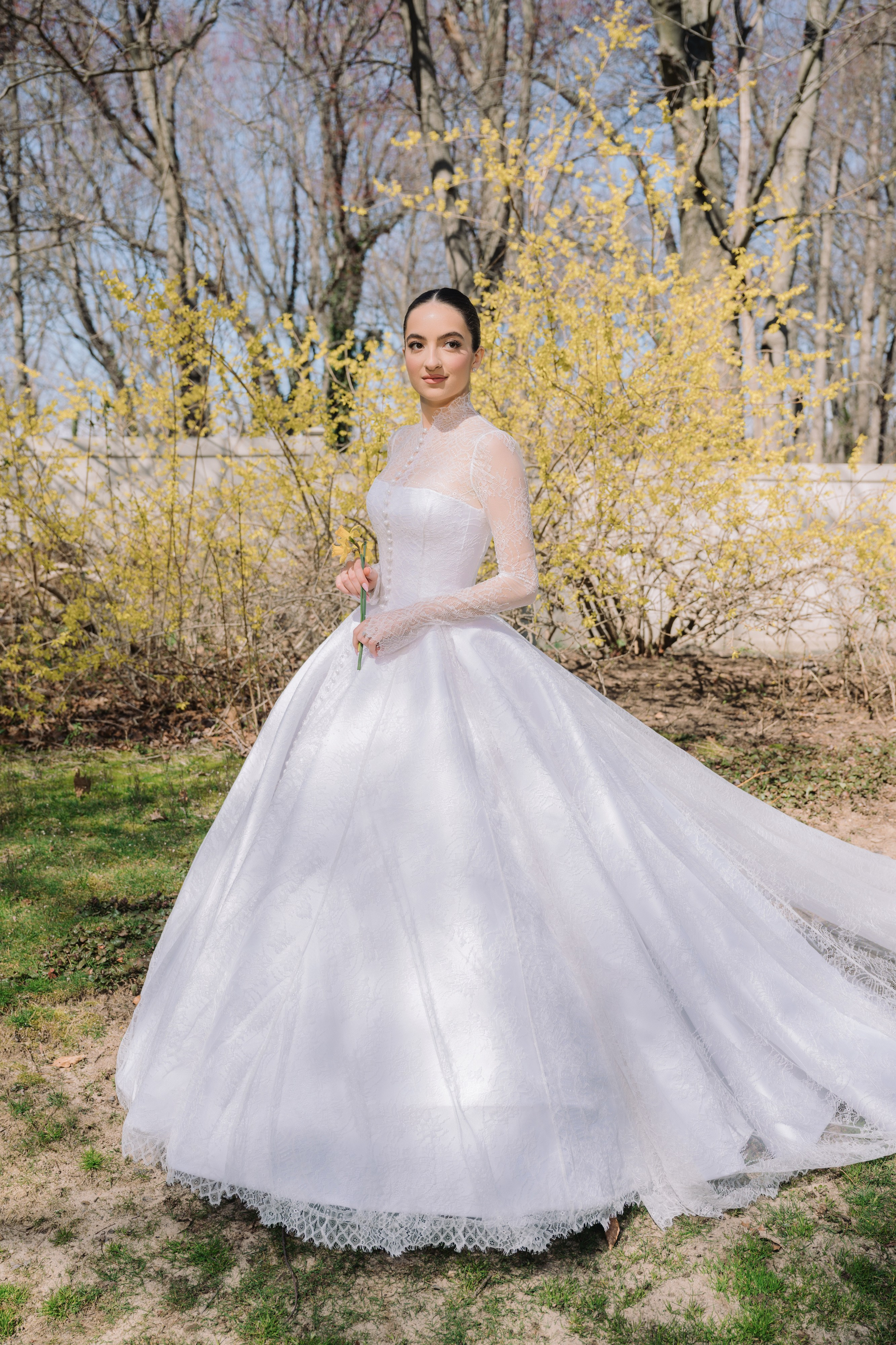 a bride in a white wedding dress standing in the grass
