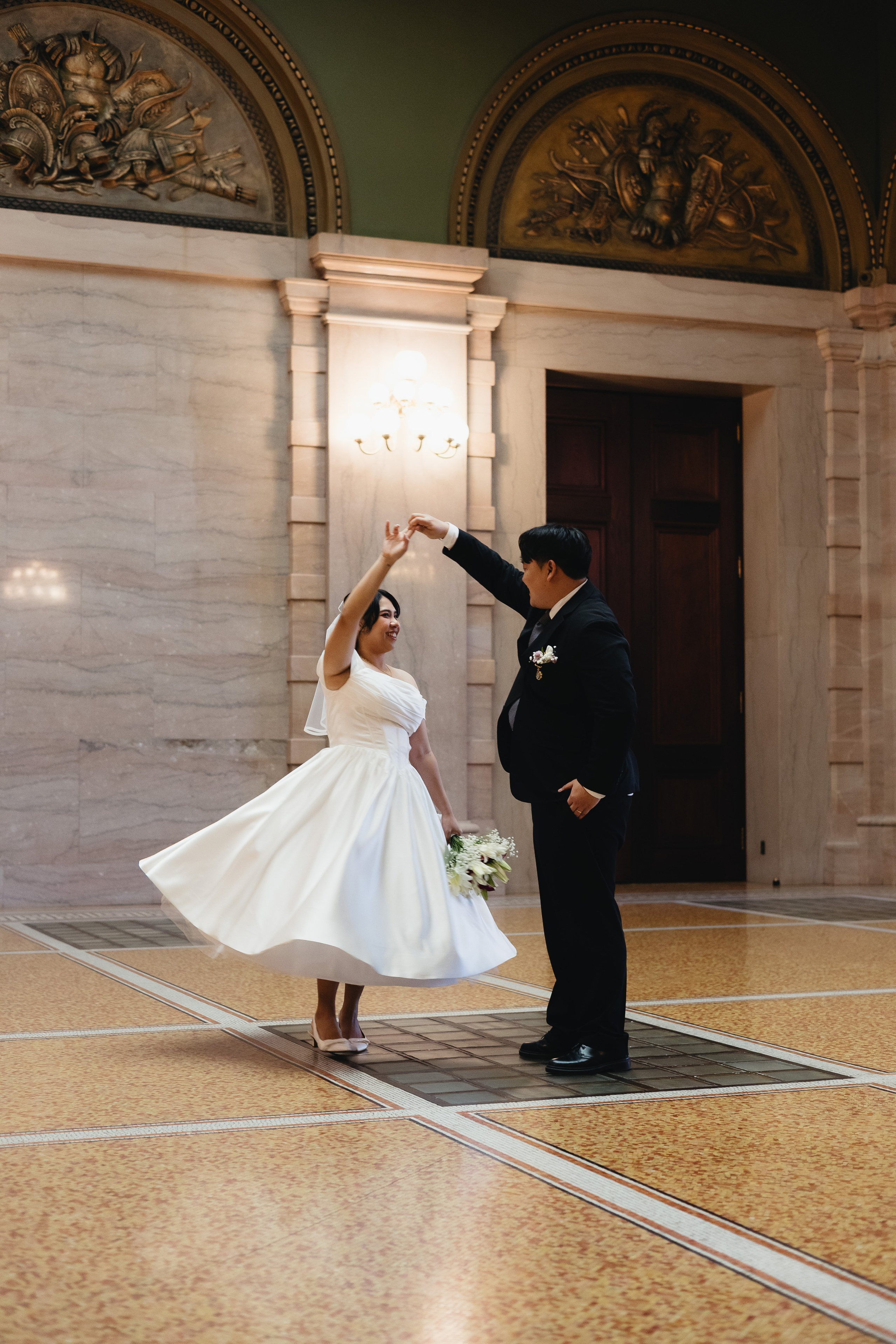 Couple dancing inside the Chicago Cultural Center, bride’s dress flowing