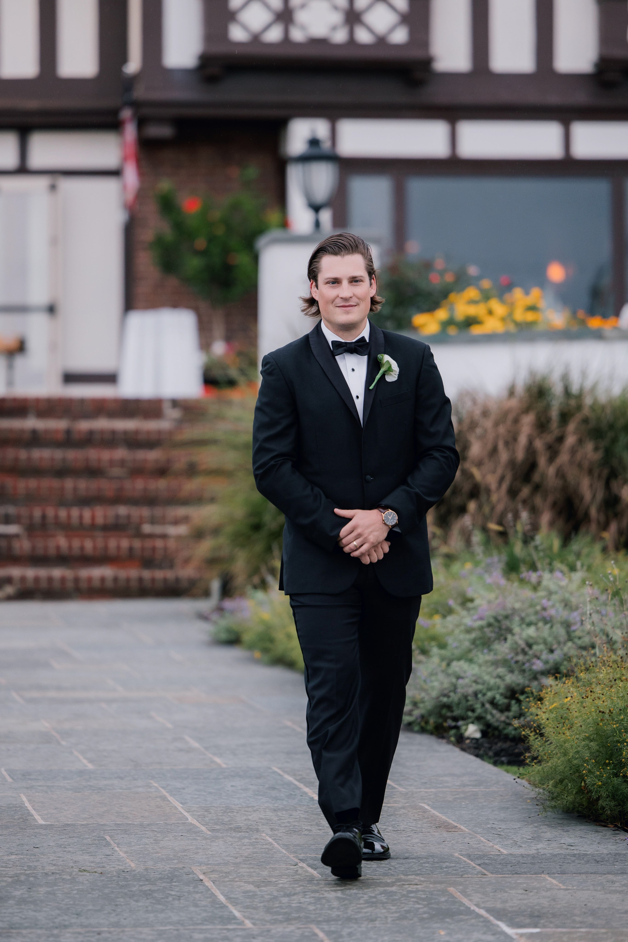 a man in a suit and tie walking down a sidewalk