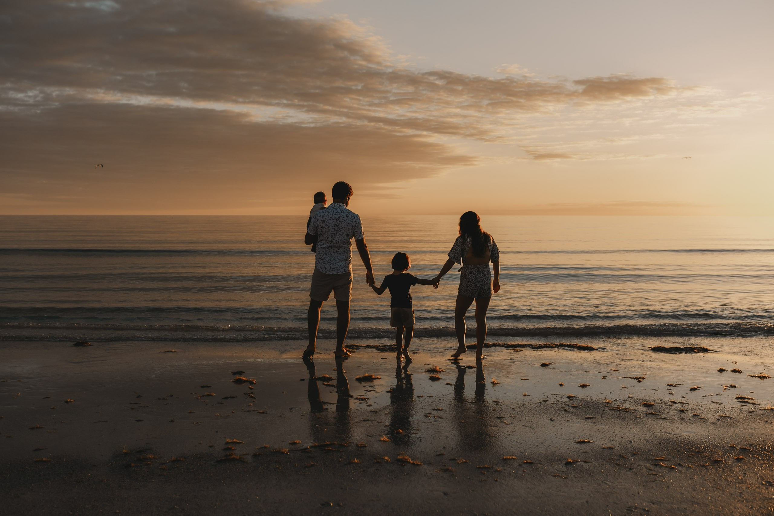 Wide shot of a family on the shore of Siesta Key Beach under a clear Florida sky