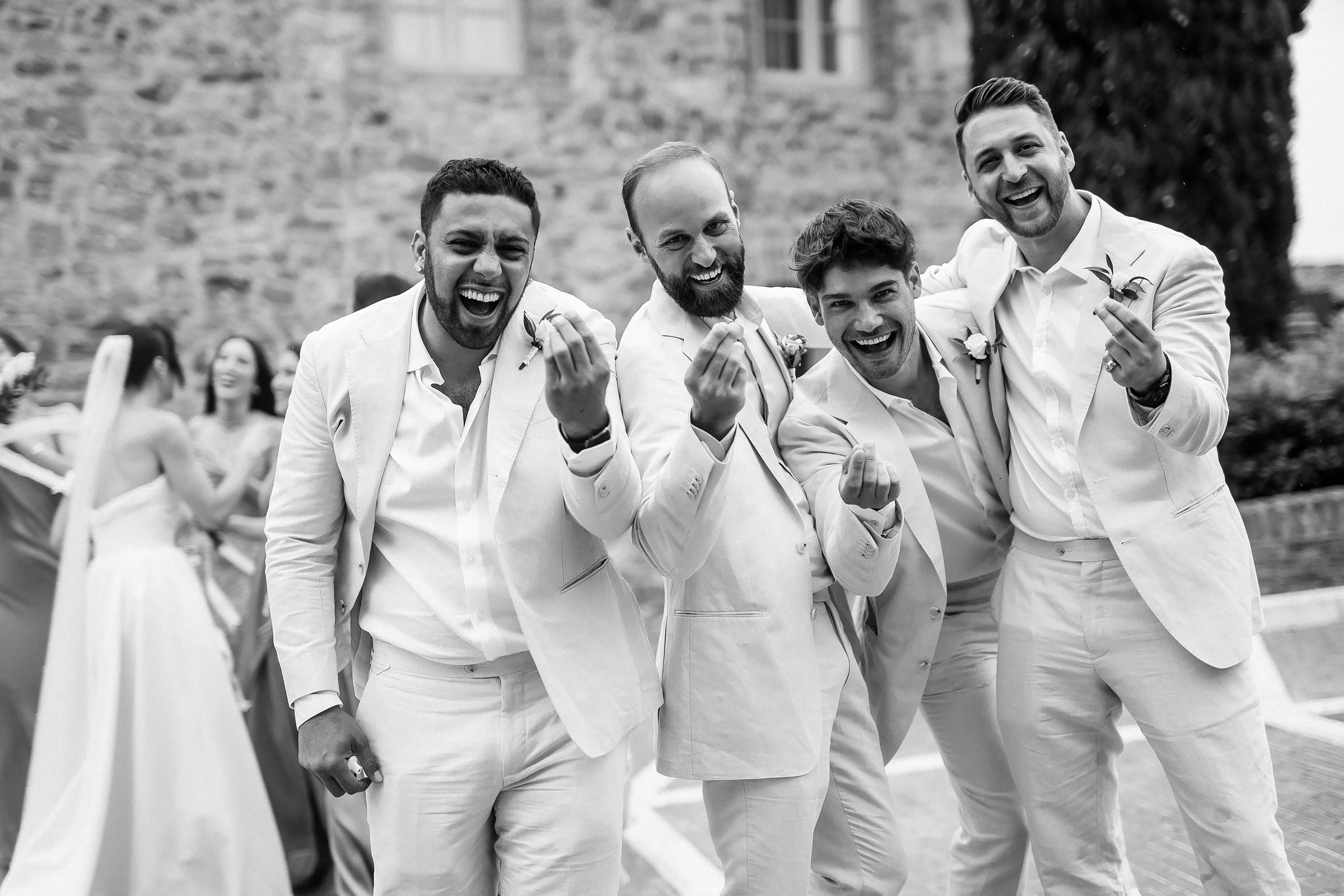 Groomsmen posing playfully in black and white, capturing a moment of camaraderie and fun.