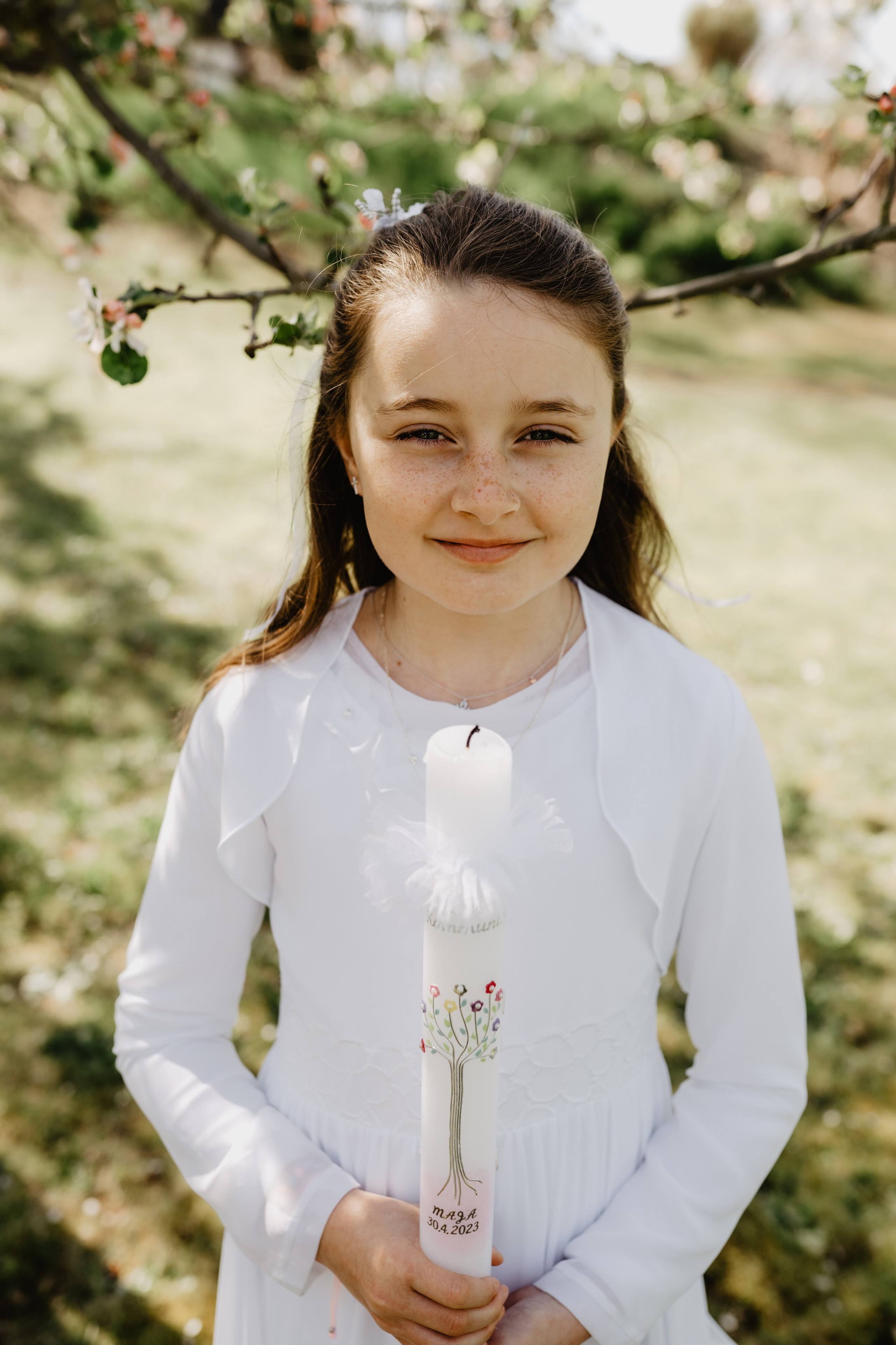 Kommunionskind nach der Zeremonie, das stolz in seinem Kommunionkleid steht