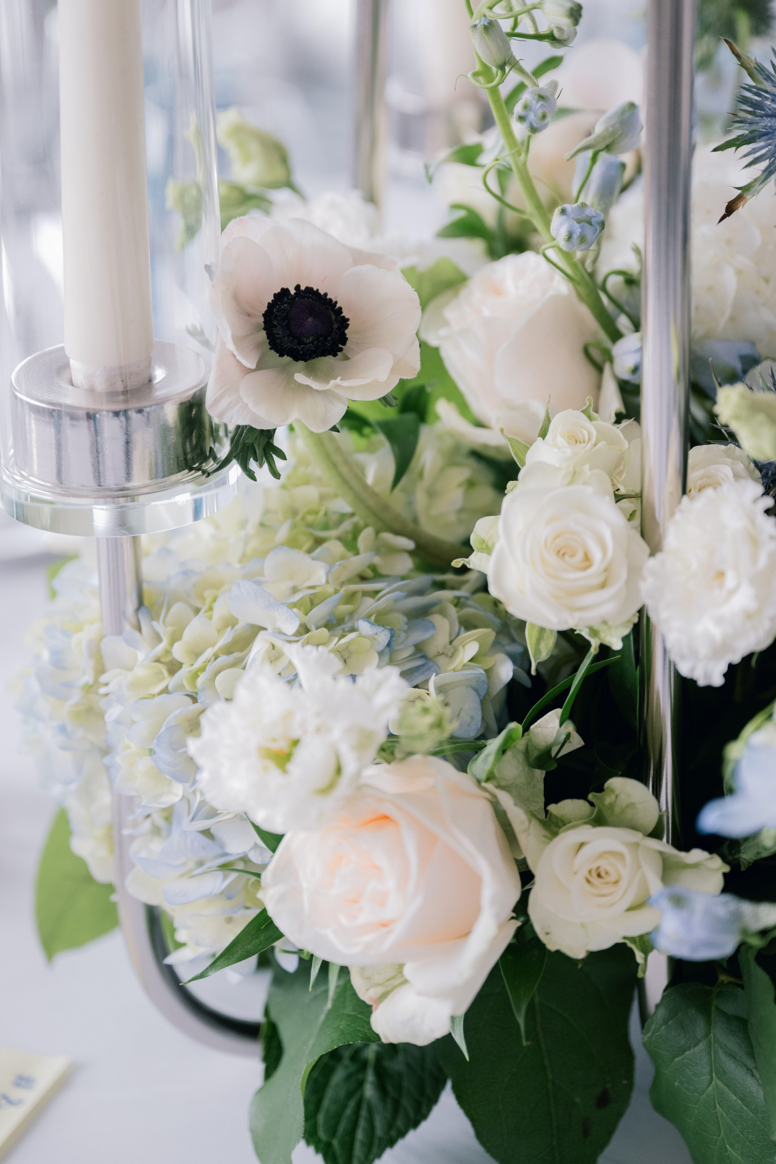a vase filled with white and blue flowers