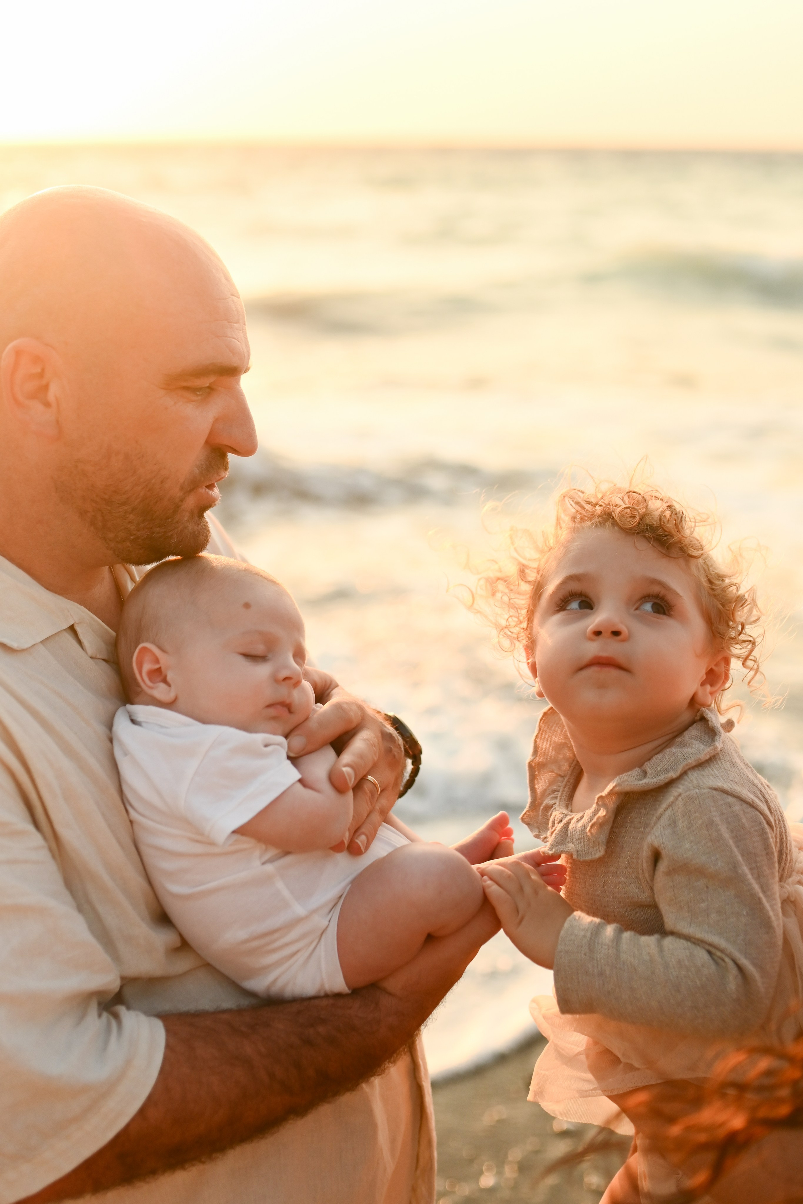 Happy family walking along a Rhodes beach at sunset. Photographer in Rhodes Island