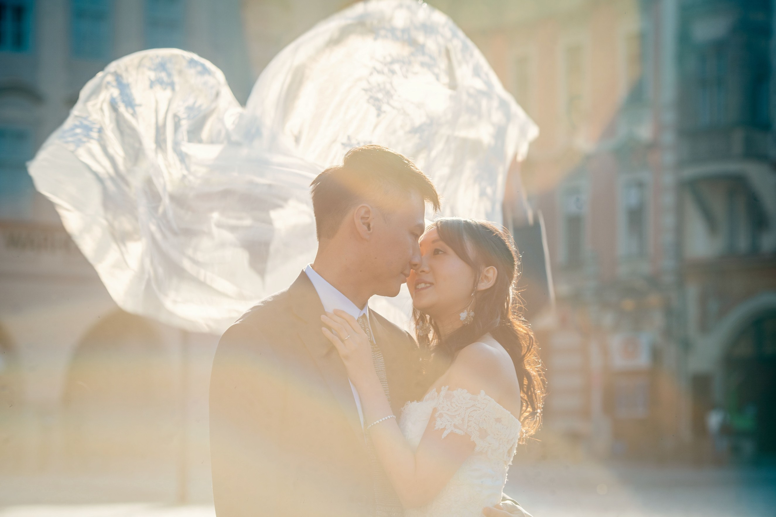 Wind lifts bride Eva’s veil to reveal the couple in a romantic moment in Old Town Square.