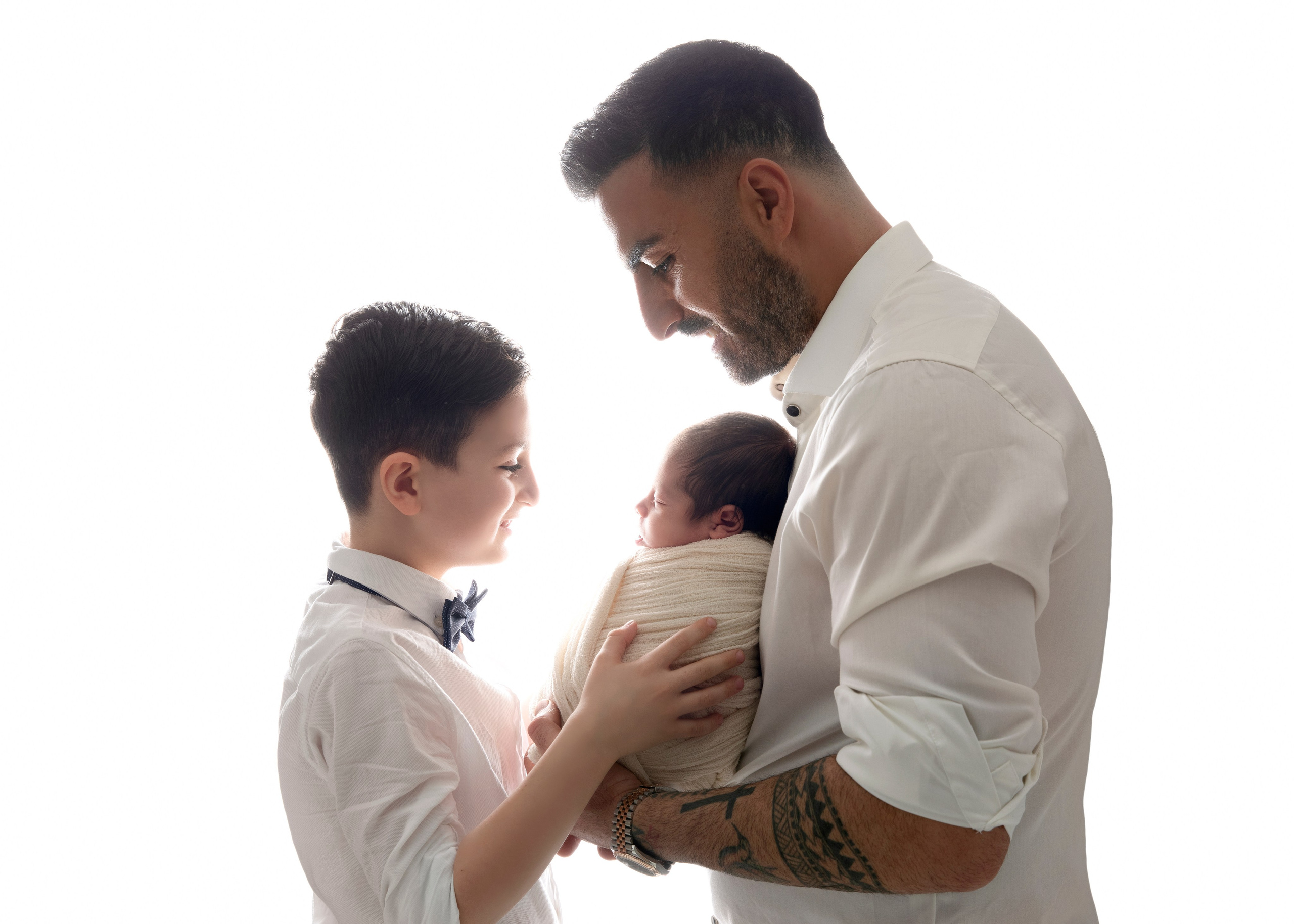 "Familjebild där föräldrarna sitter med sina nyfödda barn och äldre syskon. Bilden visar den ömma och kärleksfulla relationen mellan familjemedlemmarna och den nya tillskottet till familjen."